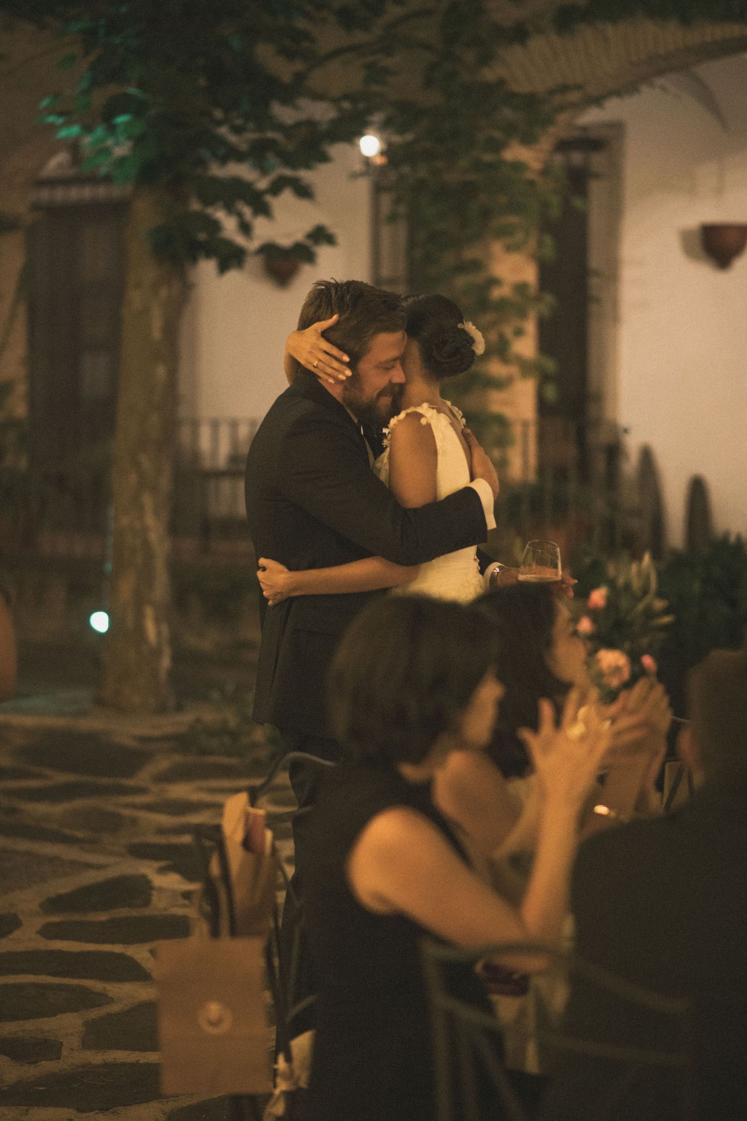 Couple dancing together on a romantic evening under trees.