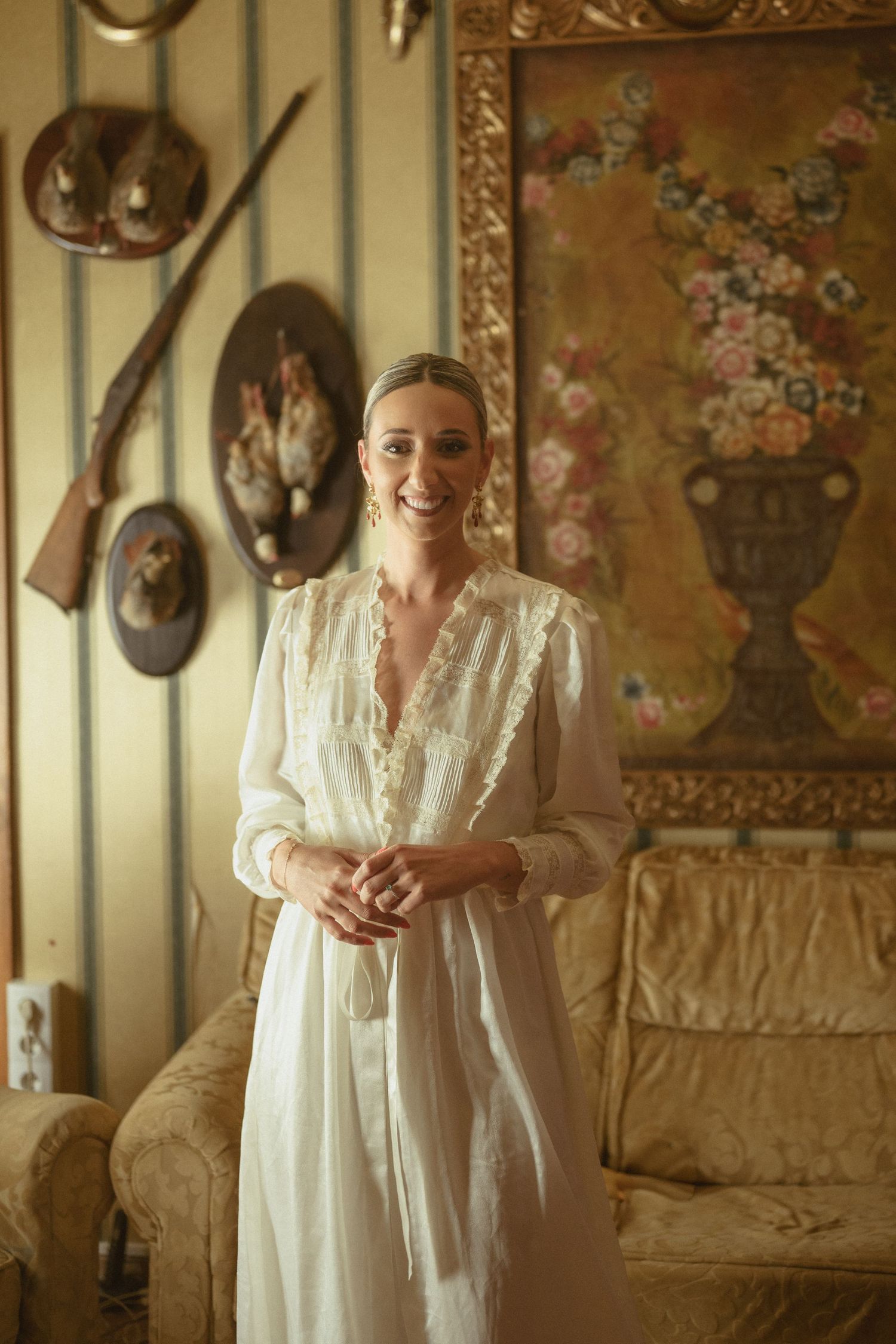 Soft natural light illuminates a vintage-styled room with ornate wall decor and antique furnishings.