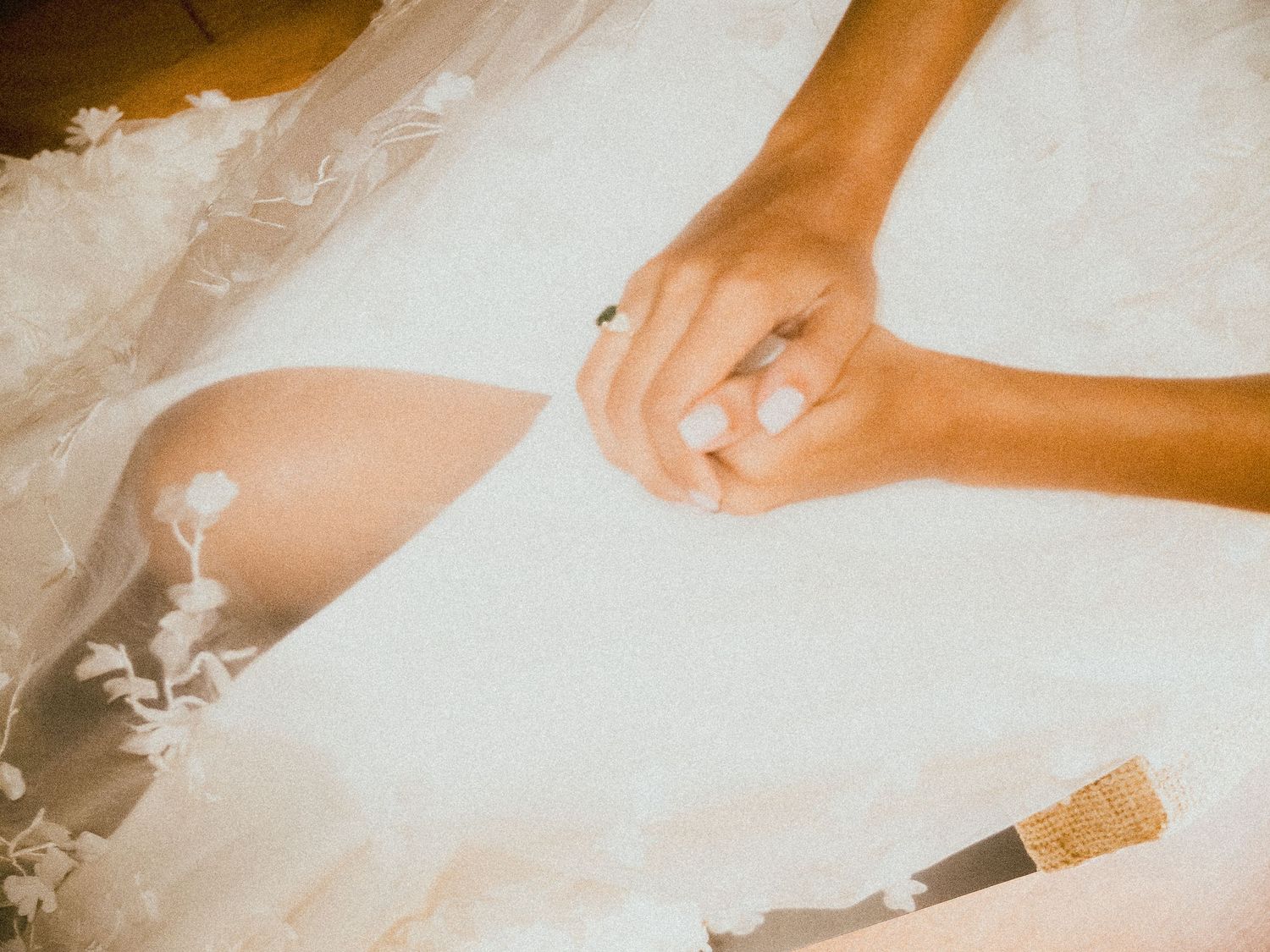 Hands adjusting formal attire against white fabric background.