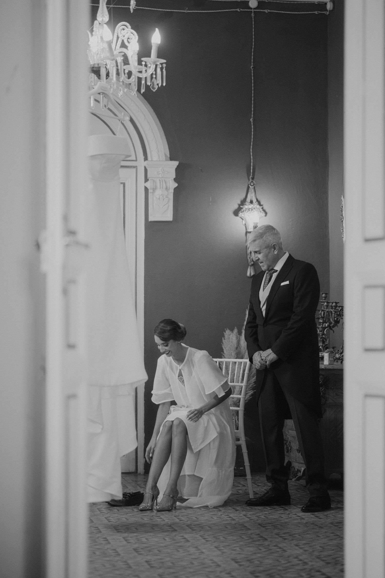 Elegant black and white wedding scene in a formal indoor venue with architectural details.
