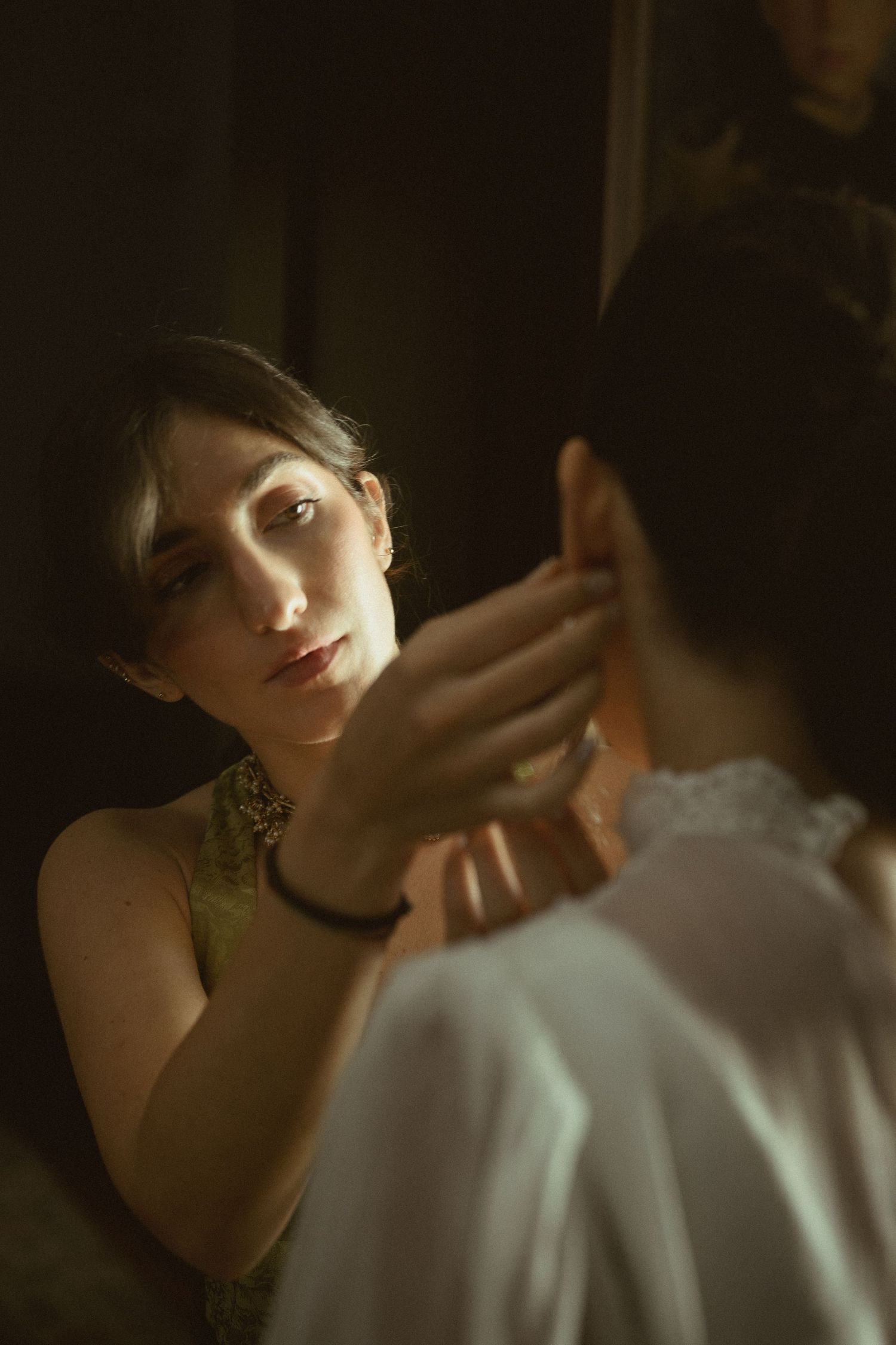Intimate moment captured in moody lighting with elegant formal attire.