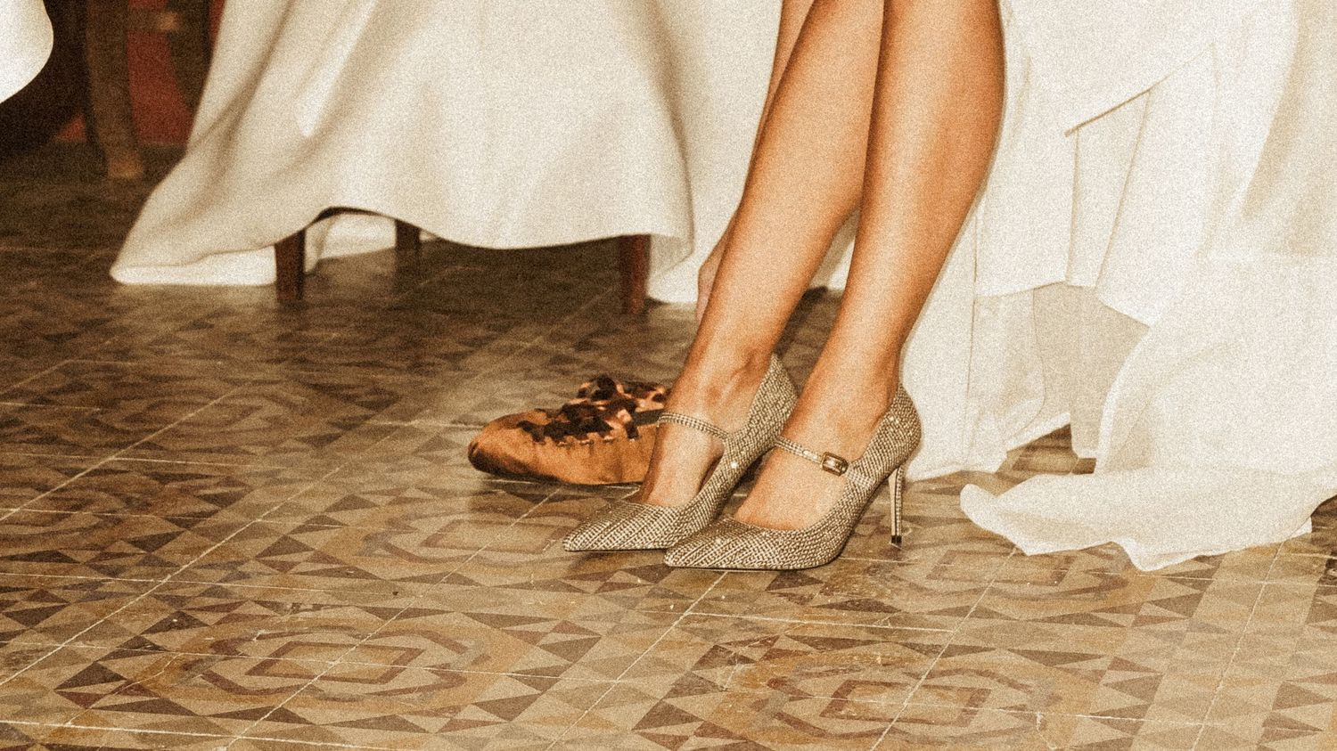 Close-up of feet in formal shoes walking across a tiled floor at a wedding.