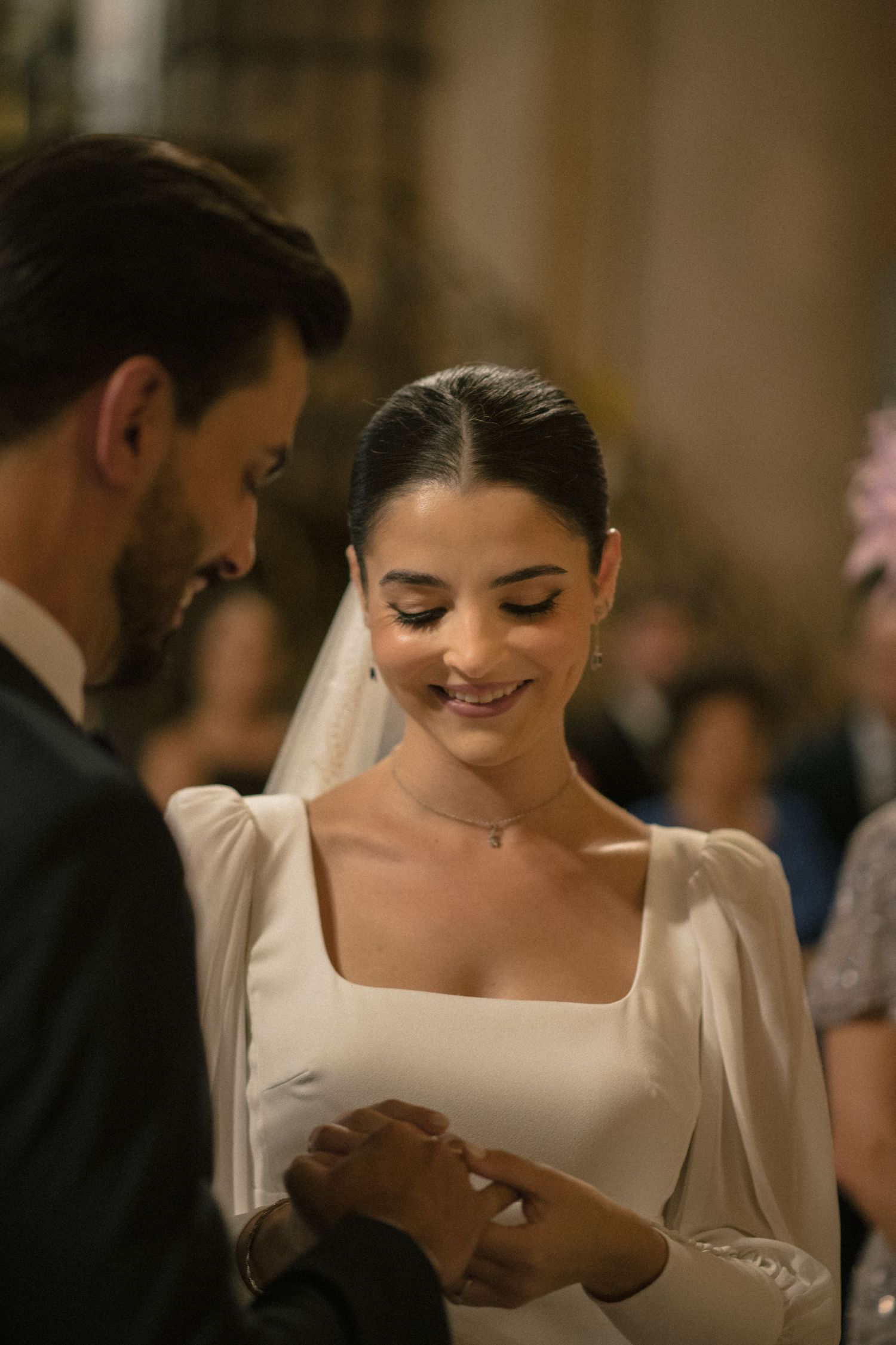 A bride in an elegant white dress reading during the ceremony.