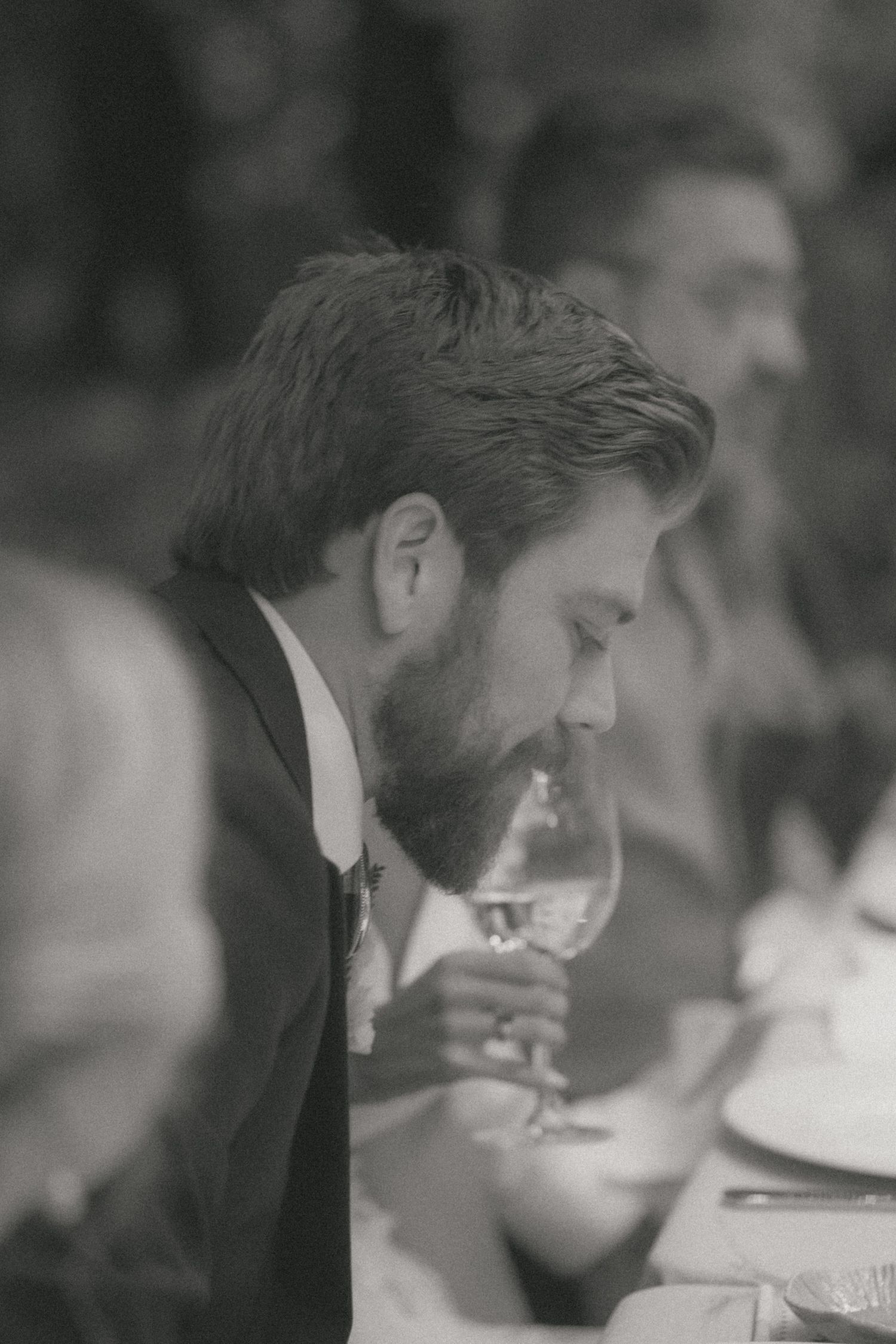 Black and white candid moment captured during an intimate wedding dinner.