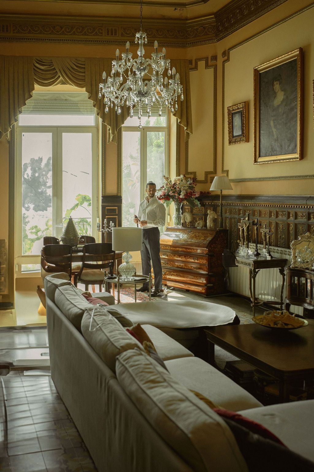 Luxurious sitting room with crystal chandelier, leather sofas and period furnishings.