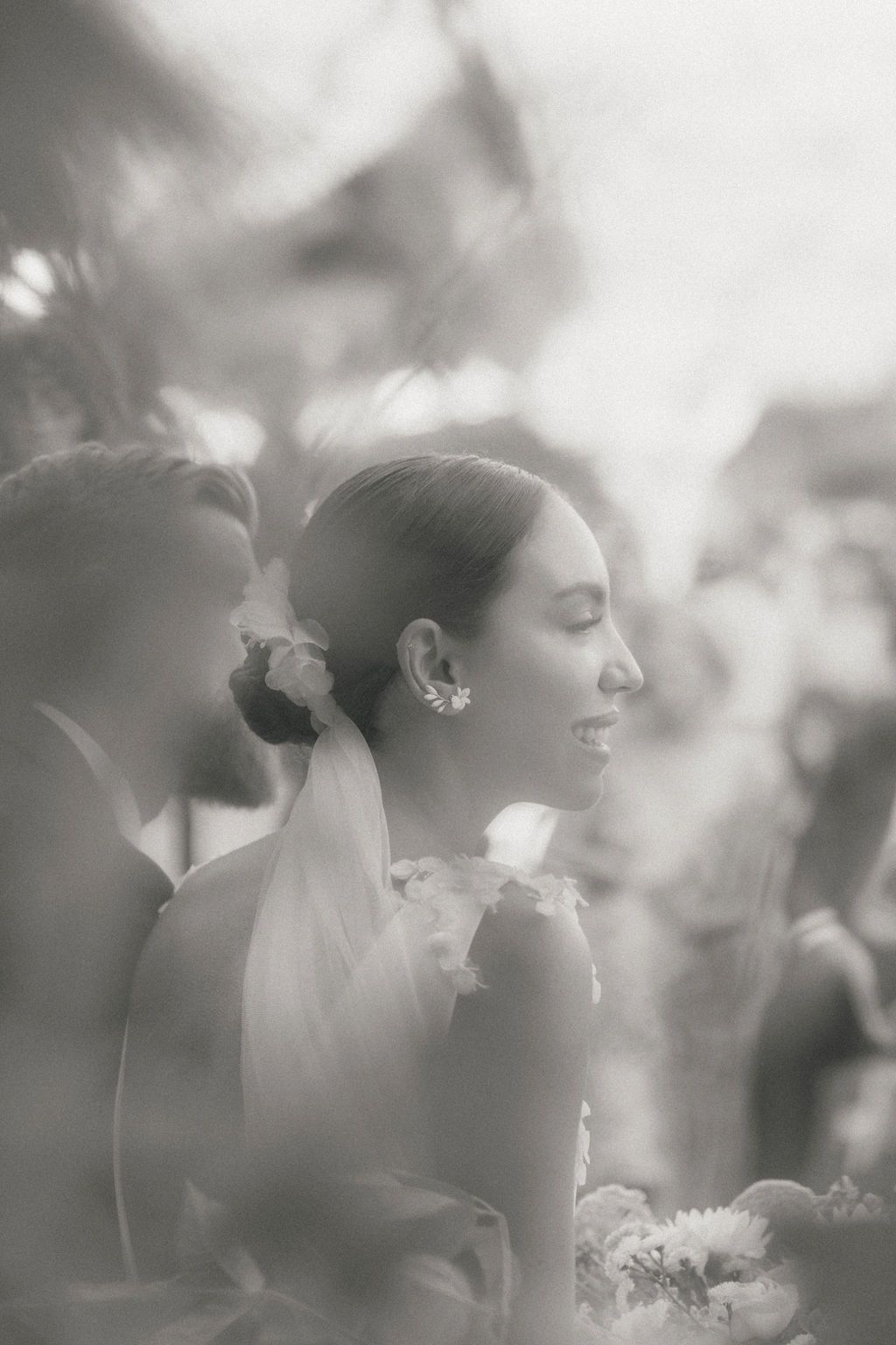 Dreamy, soft-focus portrait in ethereal lighting with floral elements.