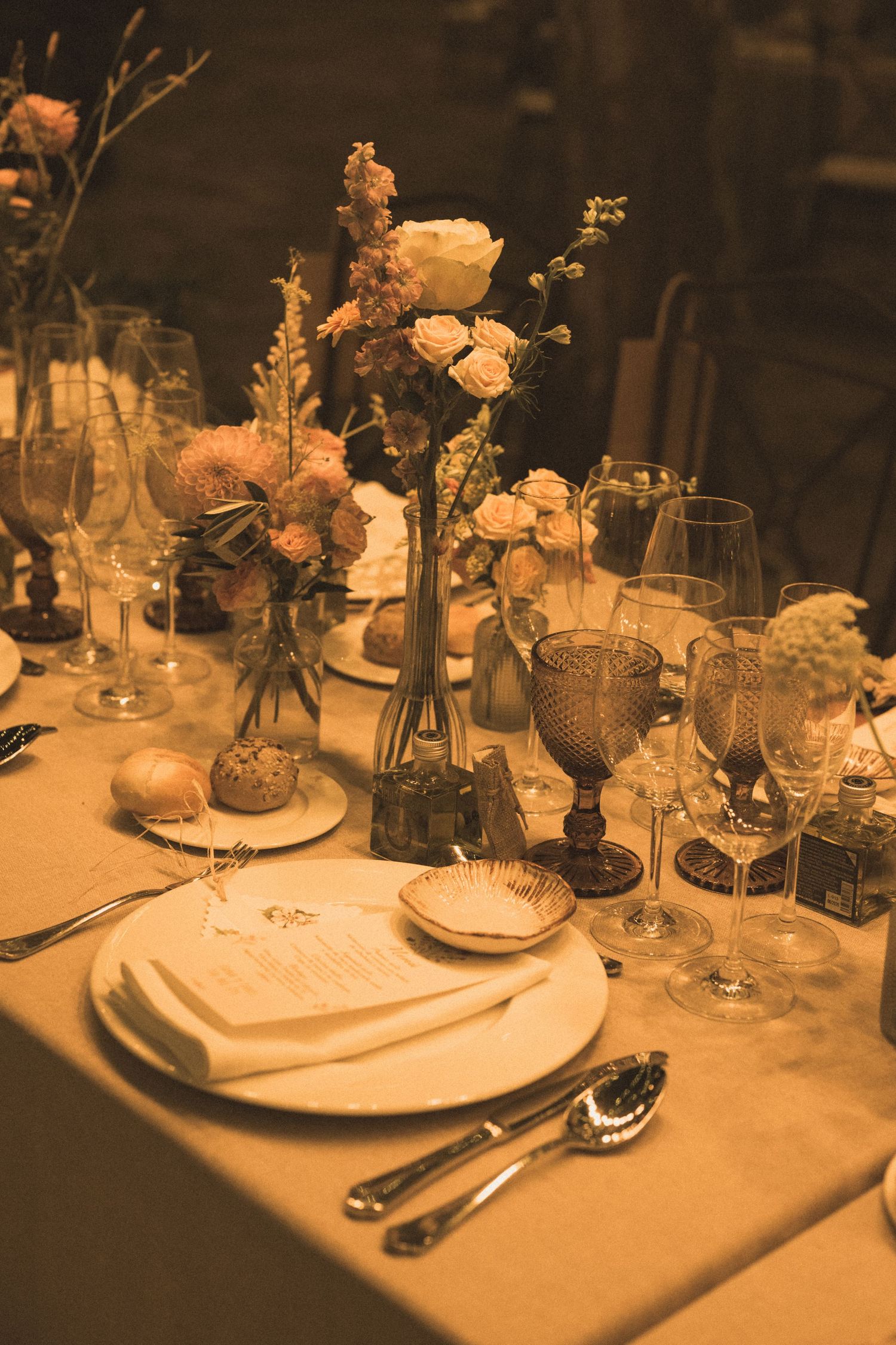 Elegant table settings with floral centerpieces and crystal glassware at a wedding reception.