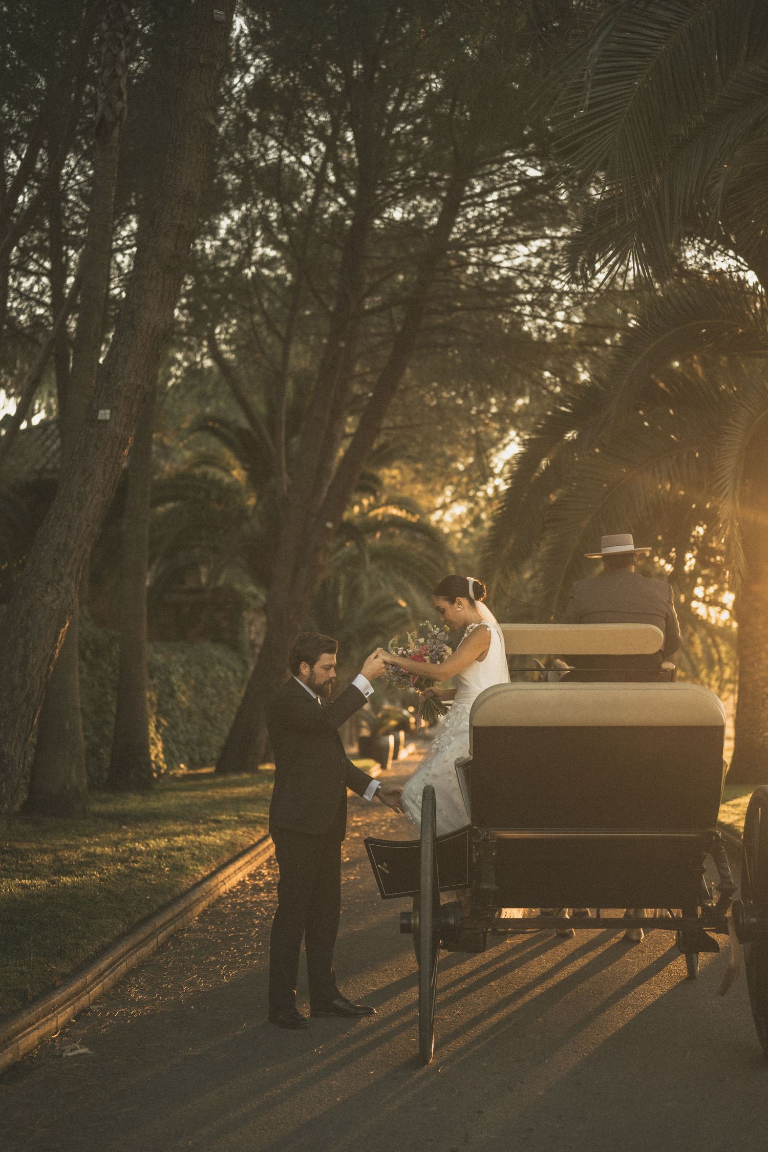 Sunset wedding portrait with couple near vintage piano creating long dramatic shadows.