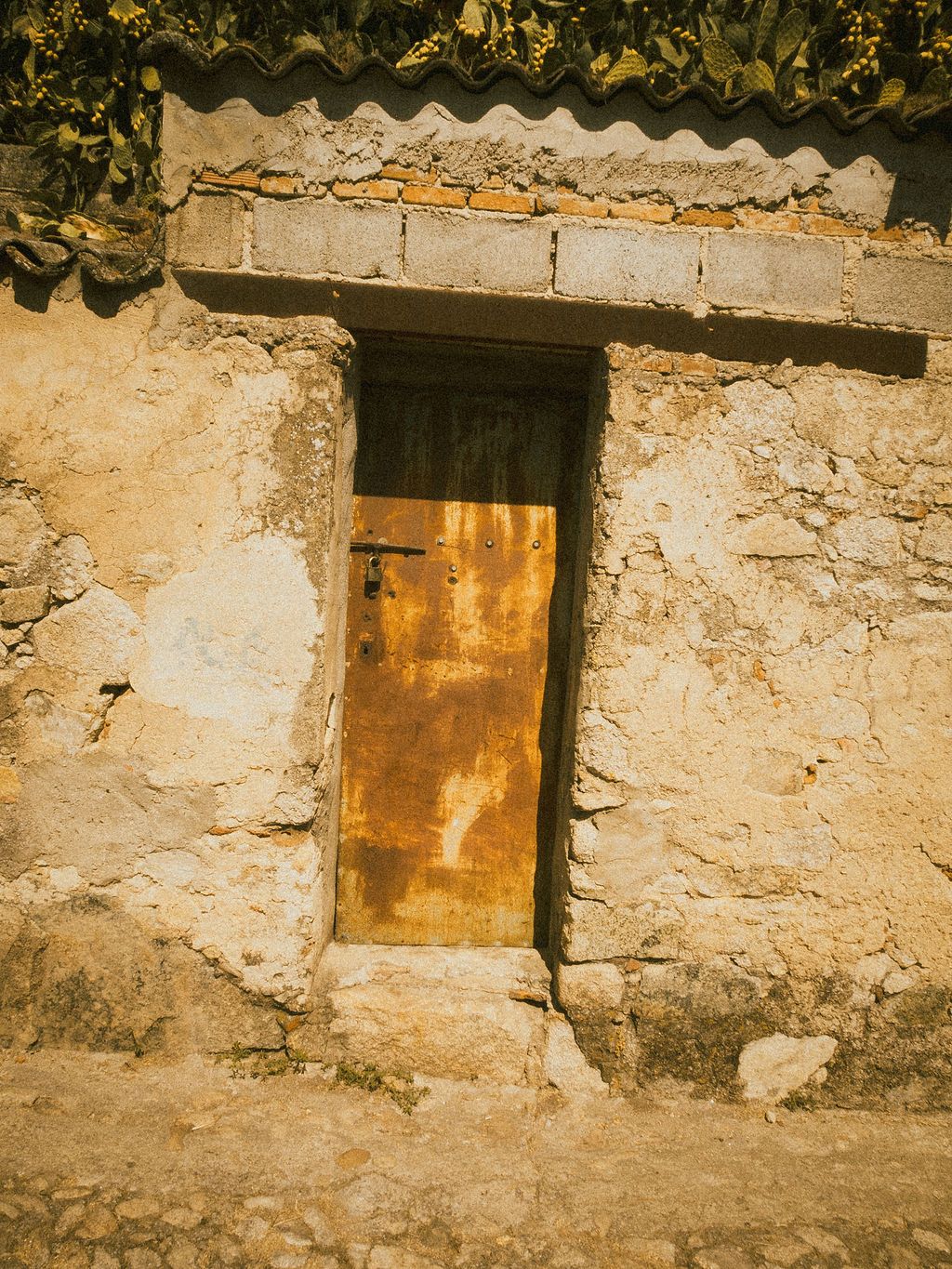 Rustic stone wall with three weathered wooden windows creating vintage architectural detail.