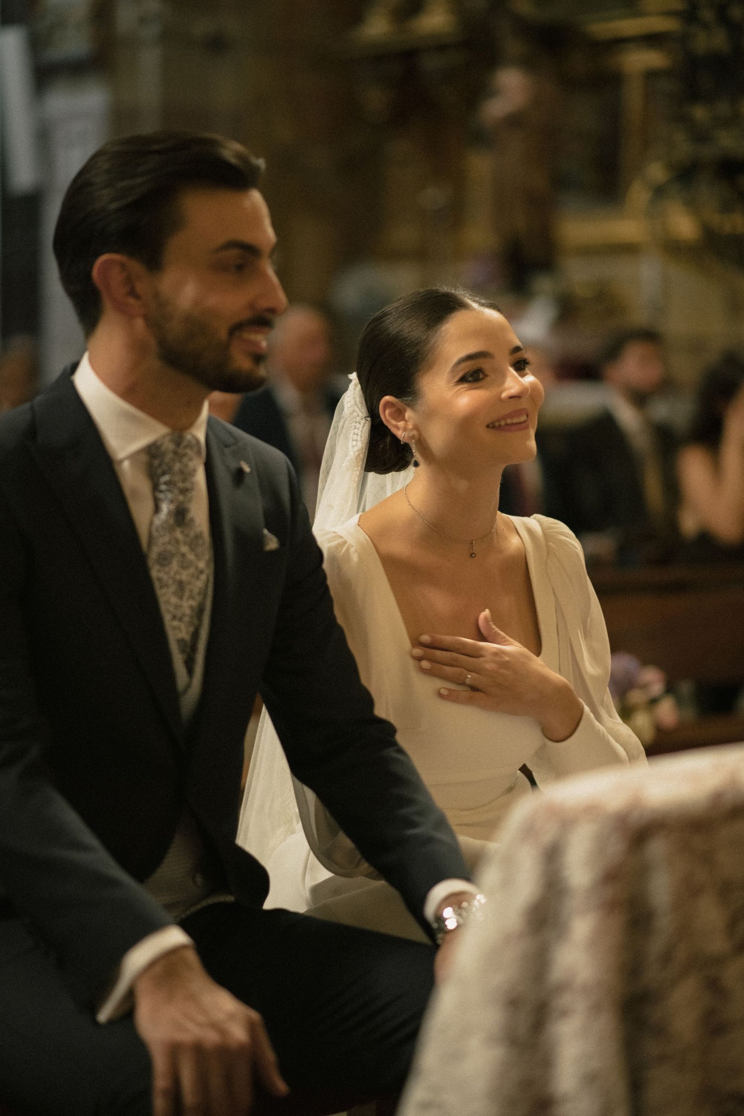 Wedding guests sharing laughter during an elegant indoor reception.