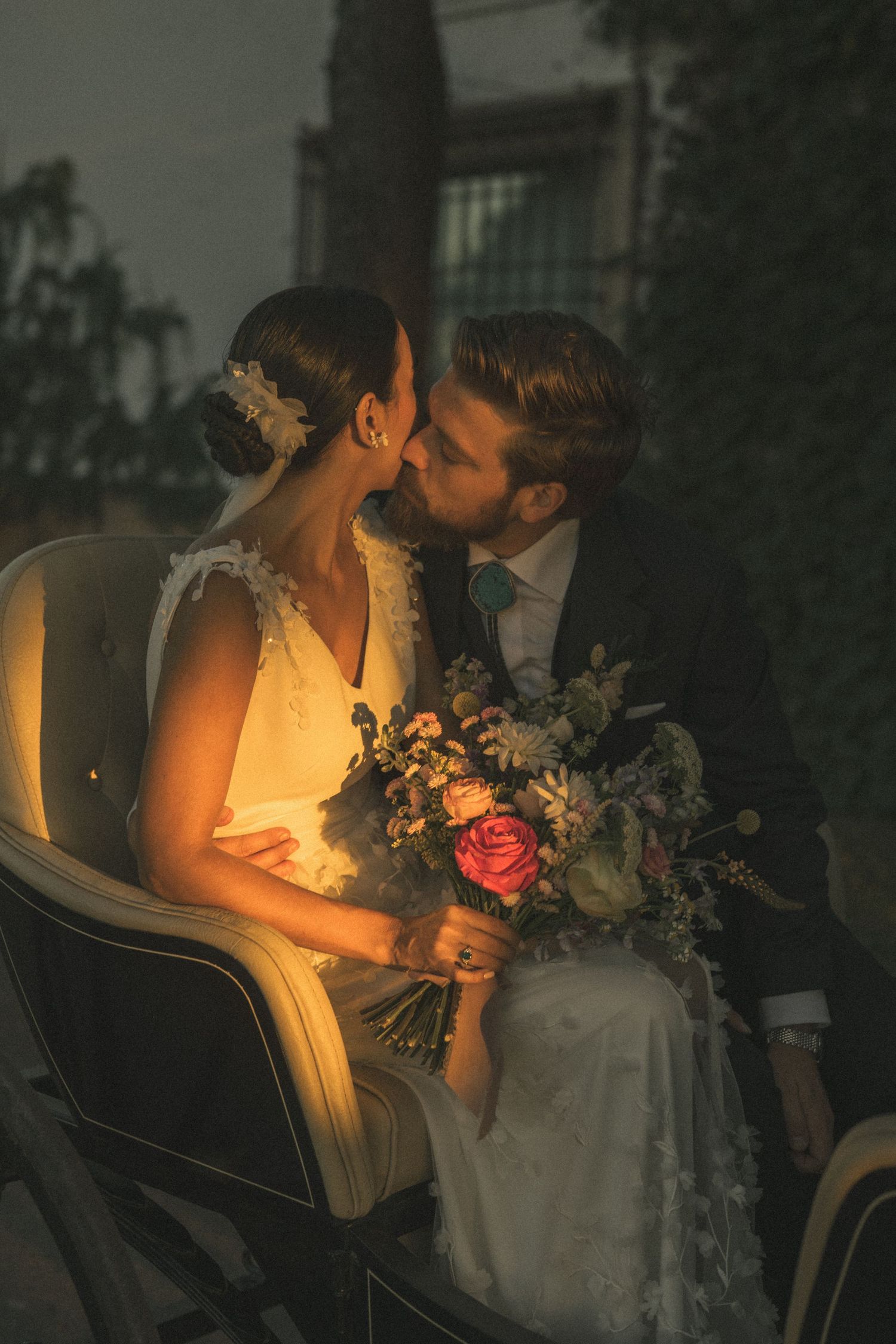 Romantic evening portrait of newlyweds with warm candlelight glow.