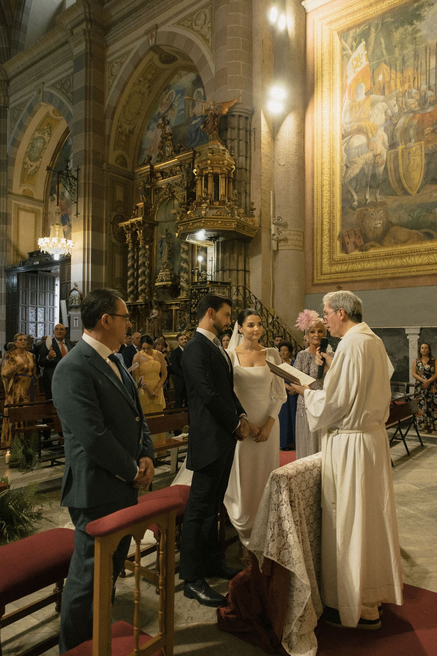 A traditional church wedding ceremony with ornate religious architecture and decor.