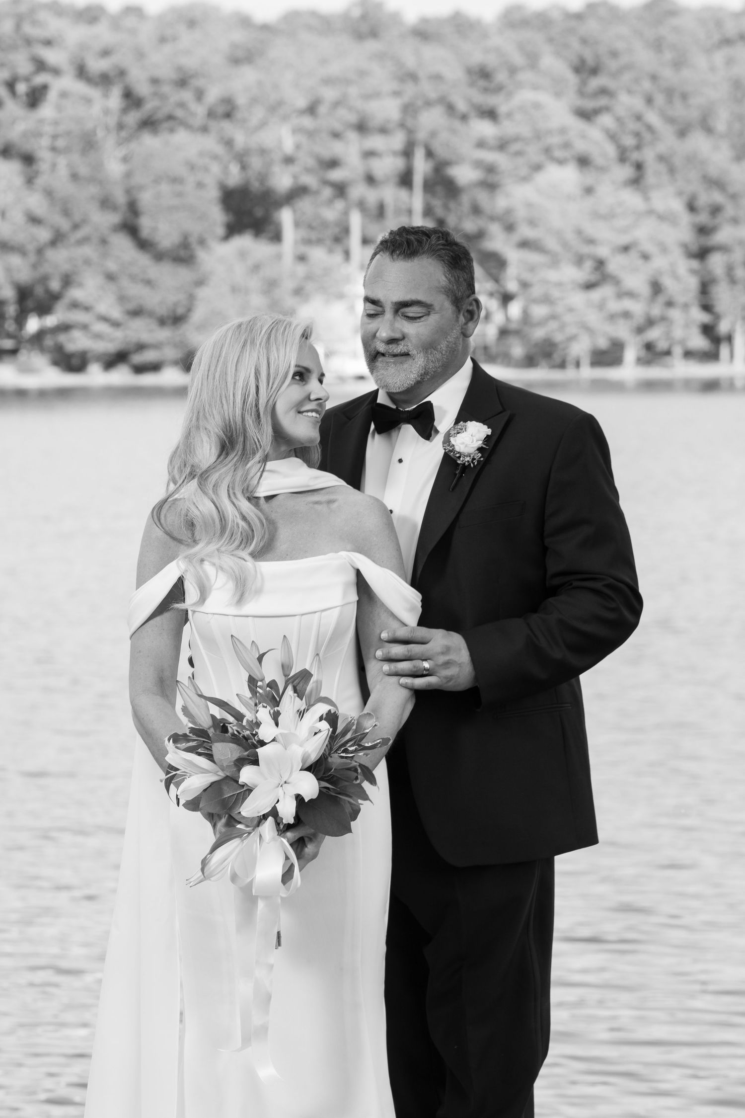 Elegant black and white wedding portrait by the waterfront.