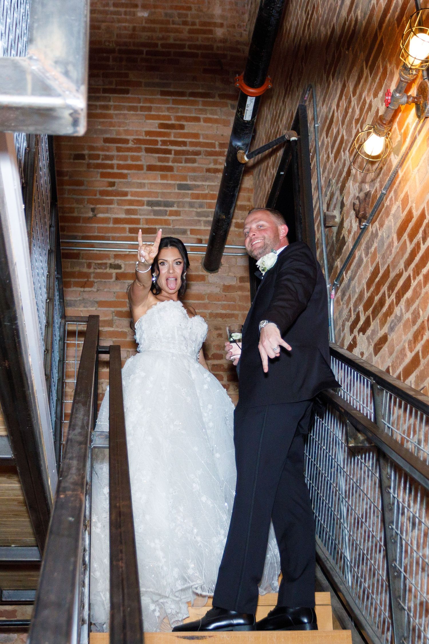 Wedding couple dancing and twirling on a rustic brick staircase.