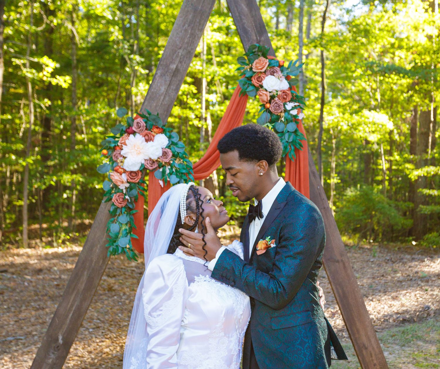 Wedding ceremony in a garden with teal and coral floral decorations.