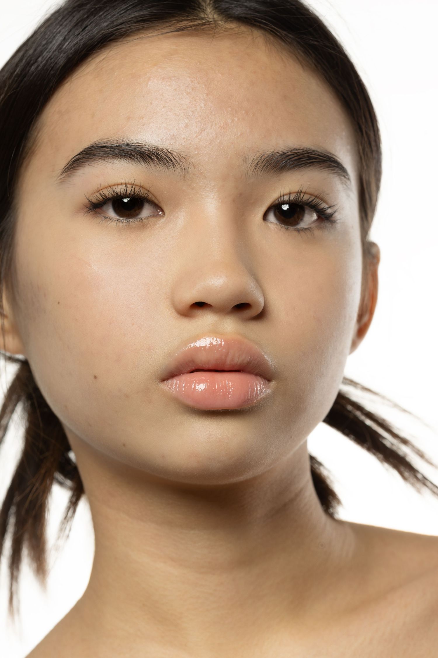 Close-up beauty portrait of young Asian woman with flawless skin and subtle makeup.