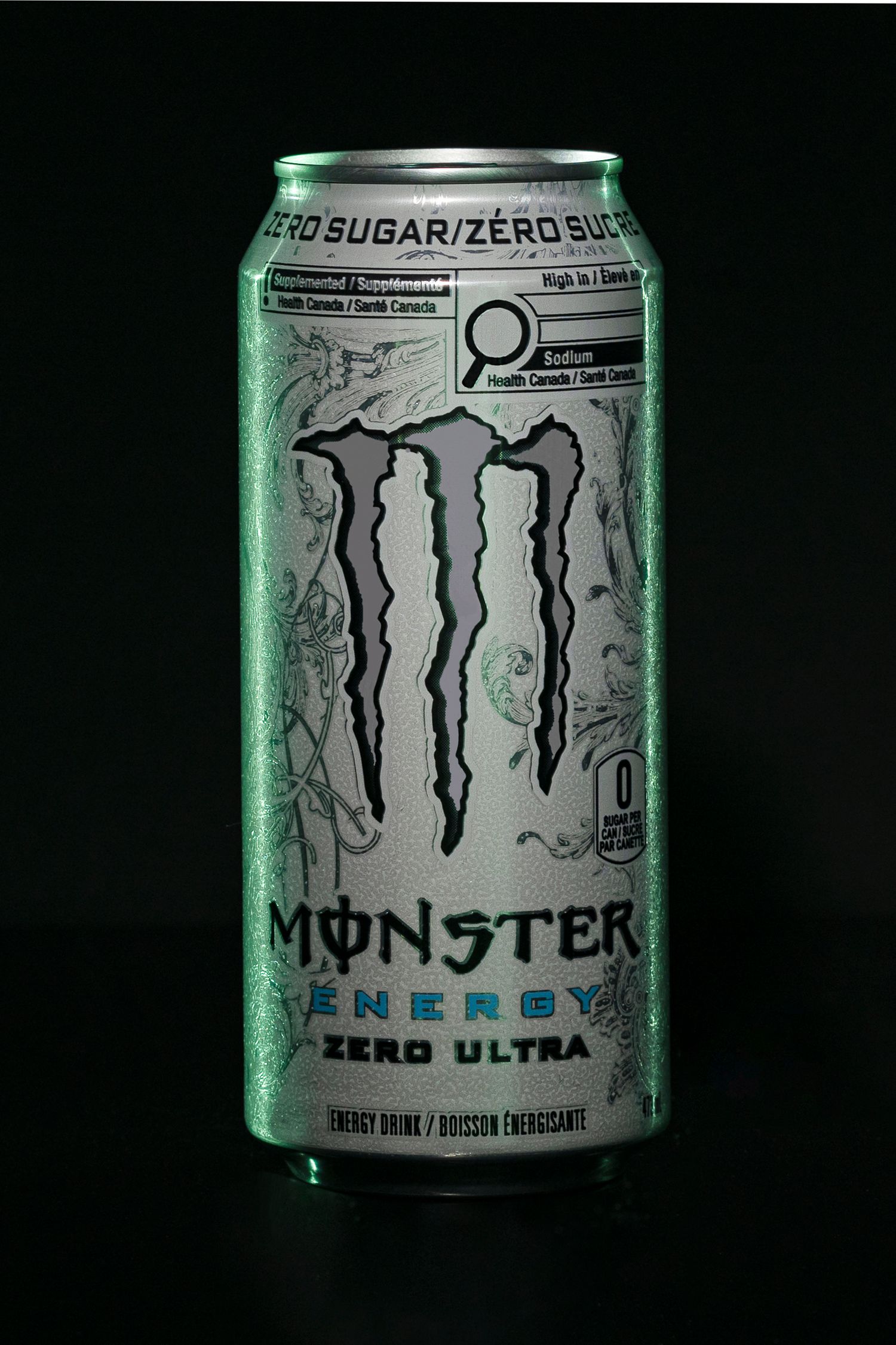 Professional product photography of Monster Energy Zero Ultra can on black background with dramatic lighting and reflection.