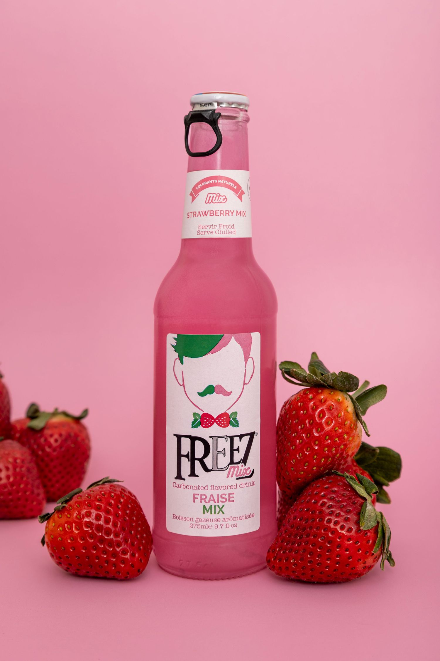 Freez strawberry soda with strawberry props on pink background
