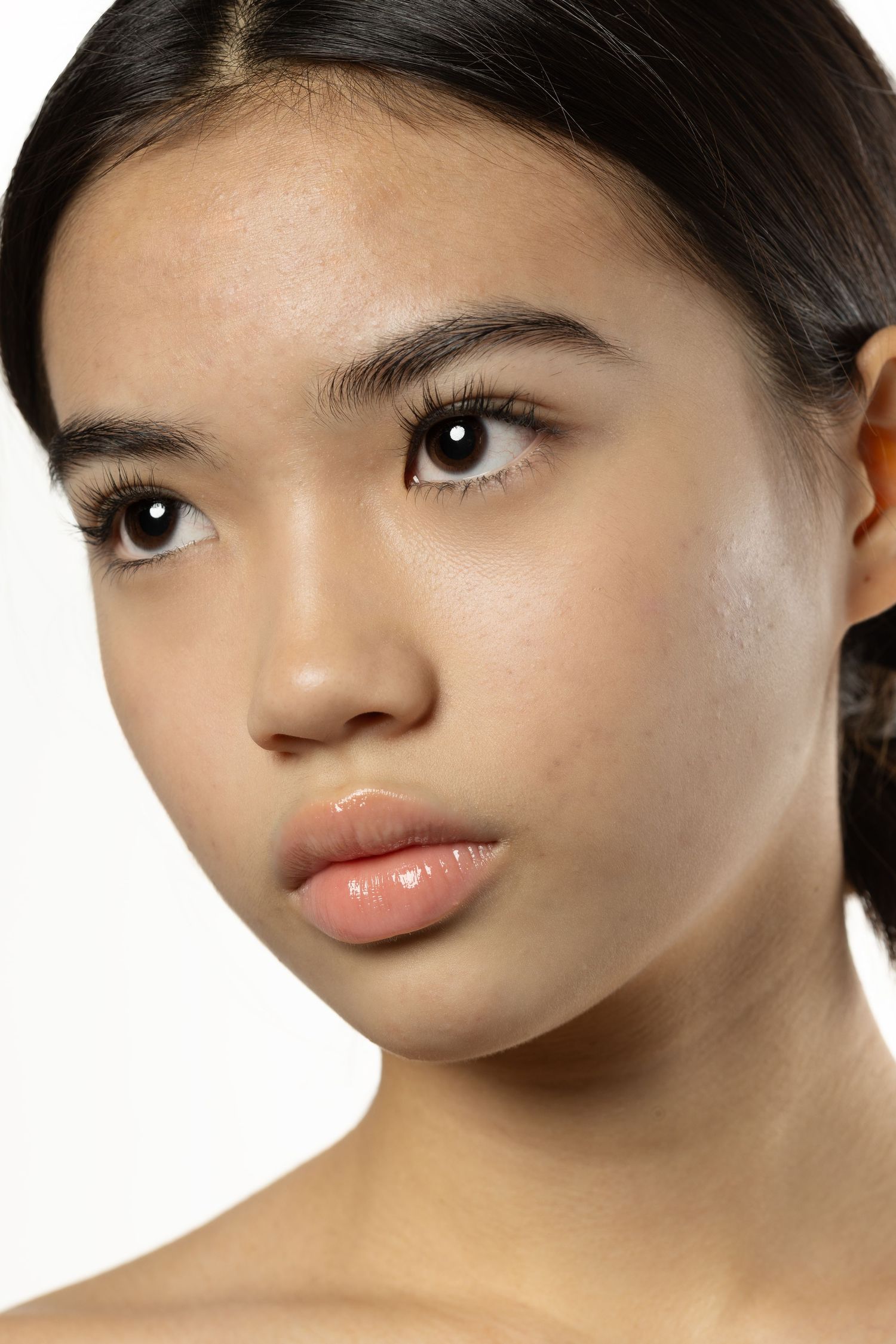 Close-up beauty portrait of young Asian woman with flawless skin and subtle makeup.