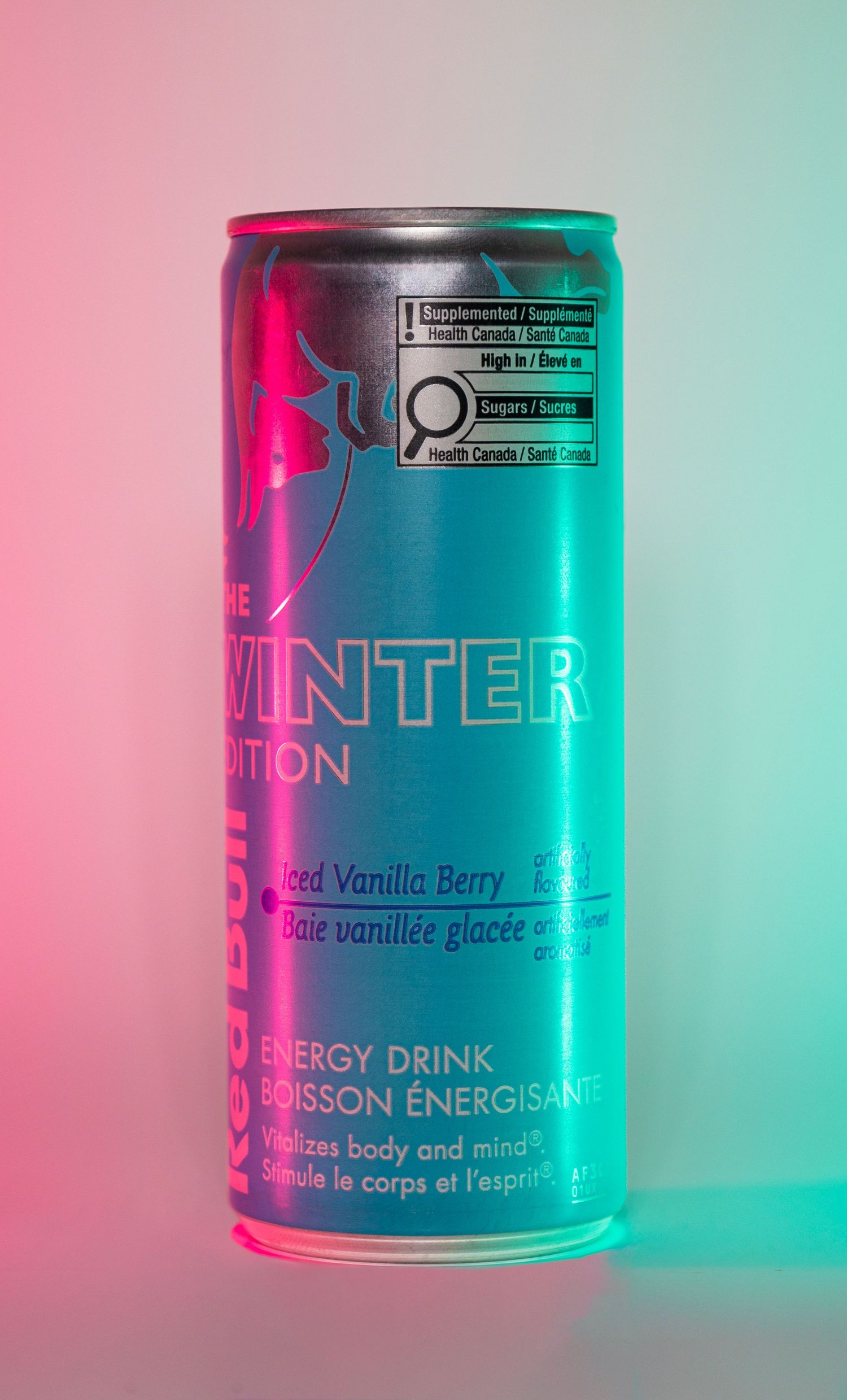 Red Bull Winter Edition can on pink and Turquoise background, energy drink product photography.