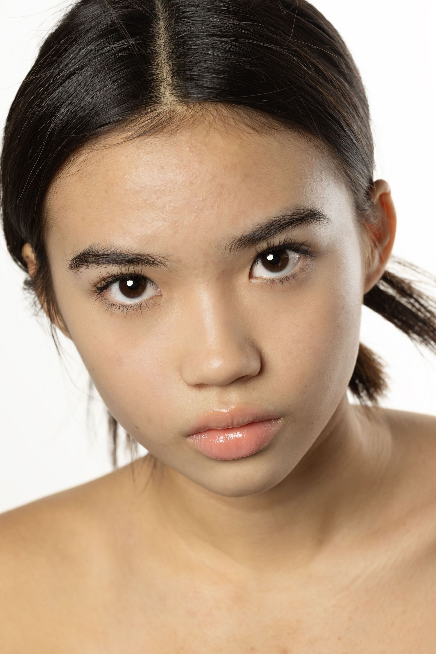 Close-up beauty portrait of young Asian woman with flawless skin and subtle makeup.