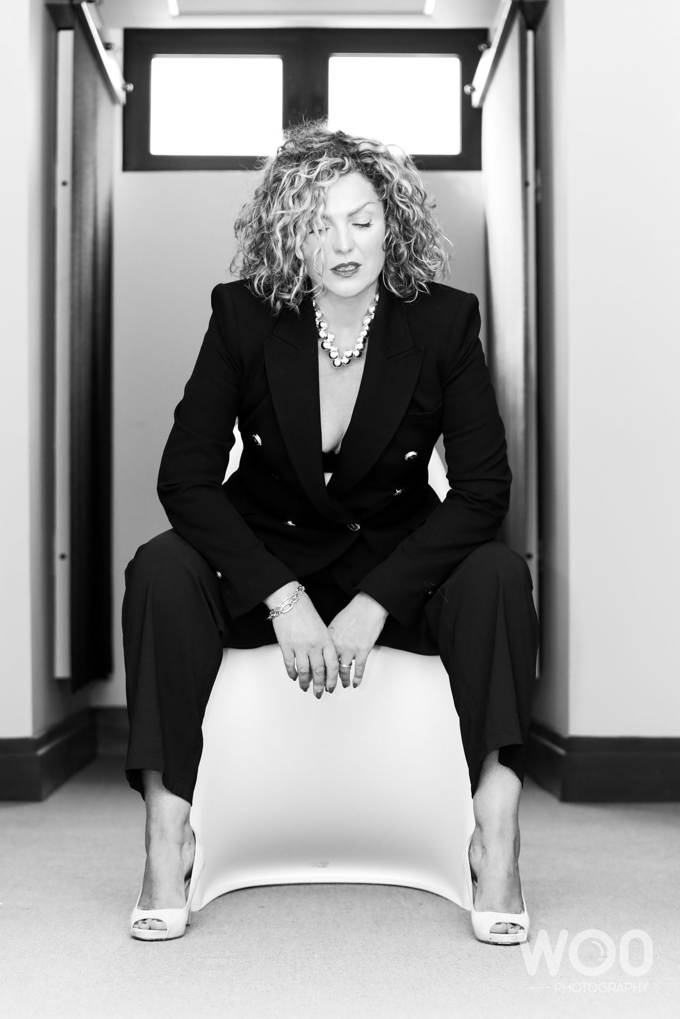 Black and white portrait series in business attire against white walls.