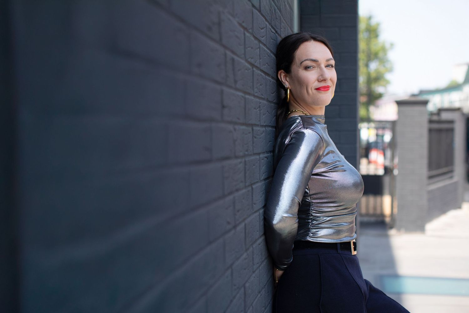 Artistic outdoor portrait series featuring minimalist style against dark wall.