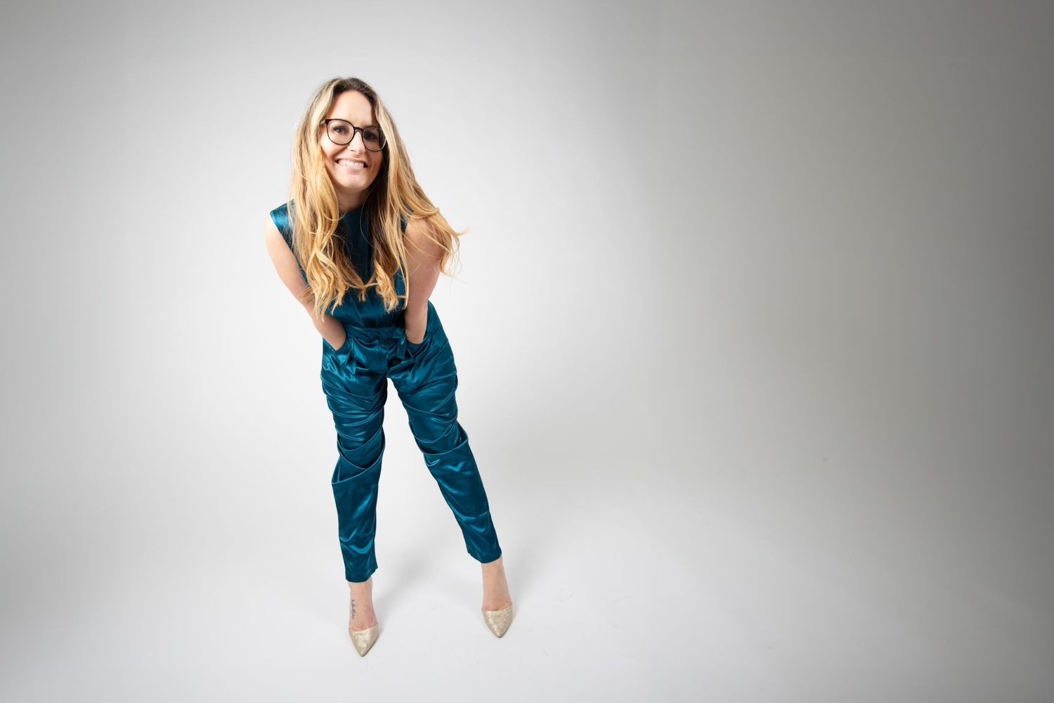 Dynamic fashion shot of someone jumping in blue outfit against grey background.