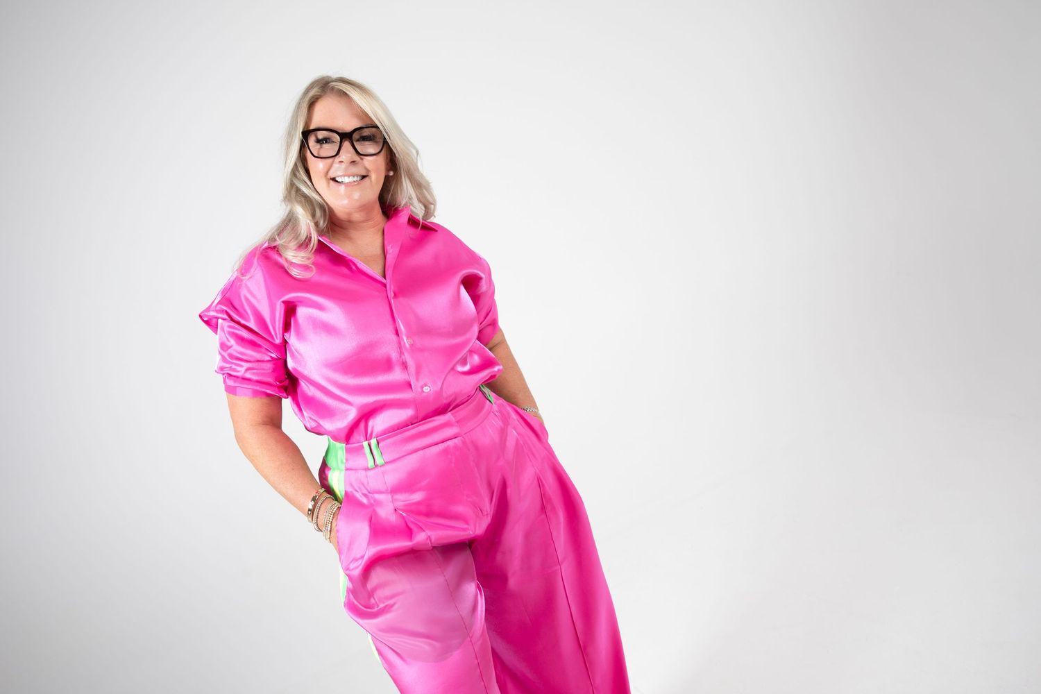 Series of poses in bright pink satin outfit against white background.