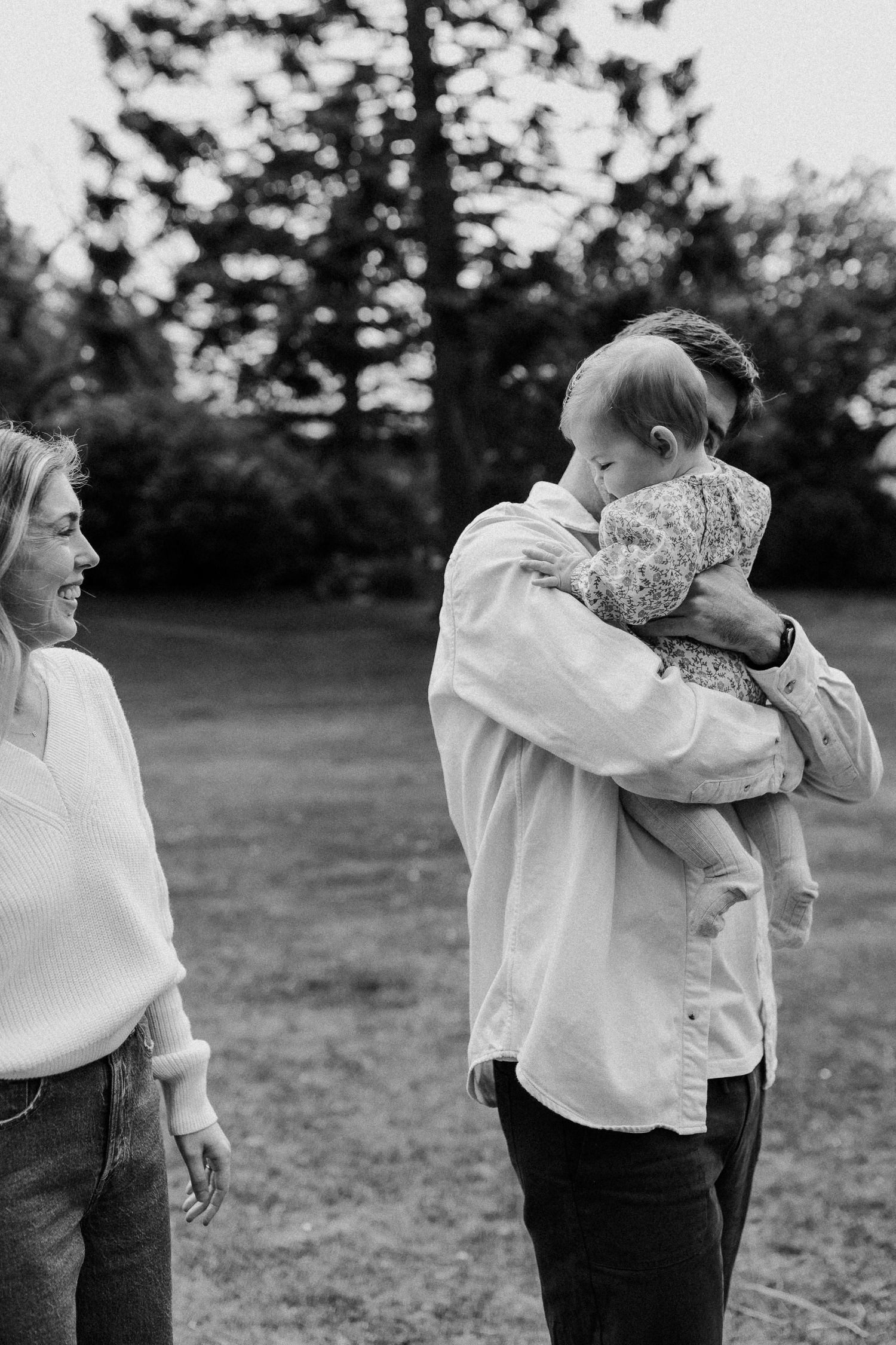 Candid black and white photos capture playful outdoor moments between people in white shirts.
