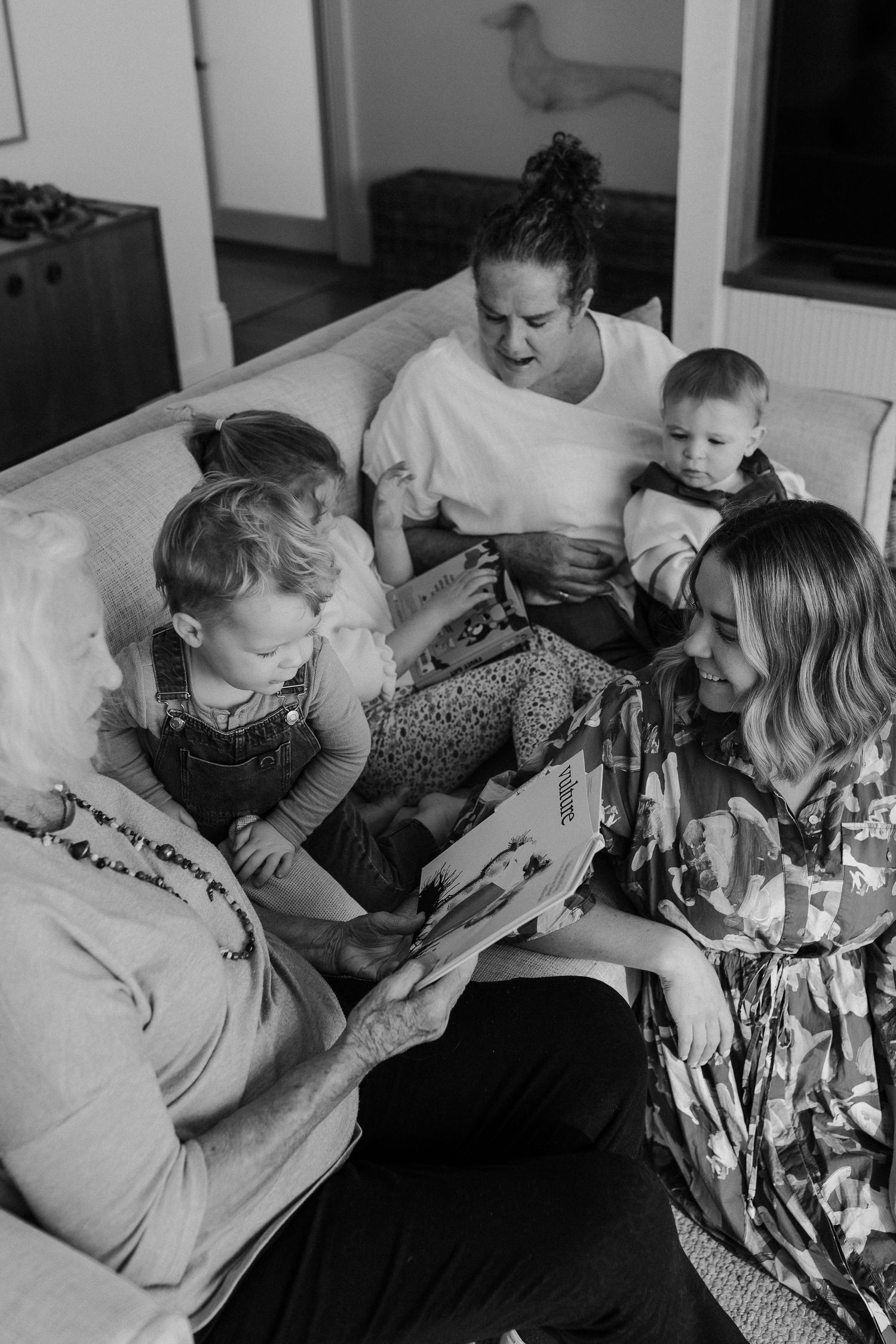 Black and white candid family moments captured on a cozy couch.