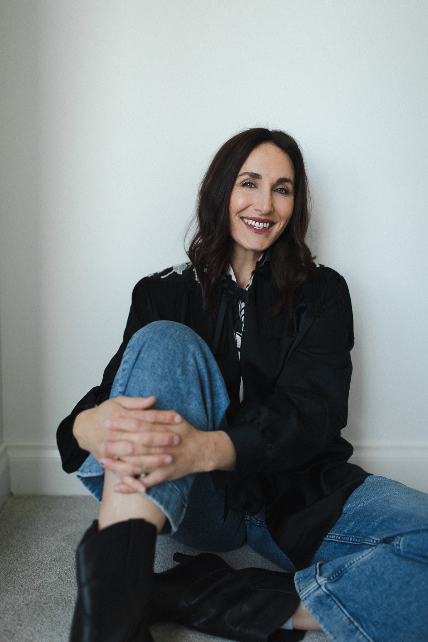 Casual portrait series against white wall showing relaxed poses in denim and black attire.