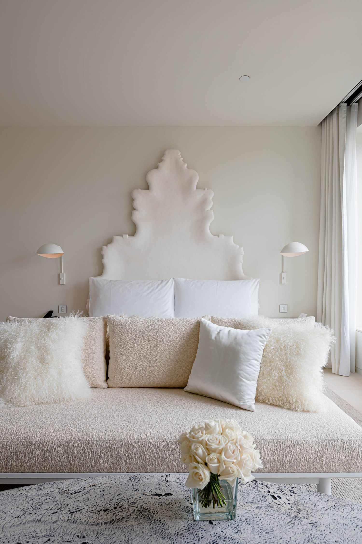 nteriorismo de hoteles: dormitorio minimalista con cabecero escultural blanco en The Madrid Edition, por John Pawson