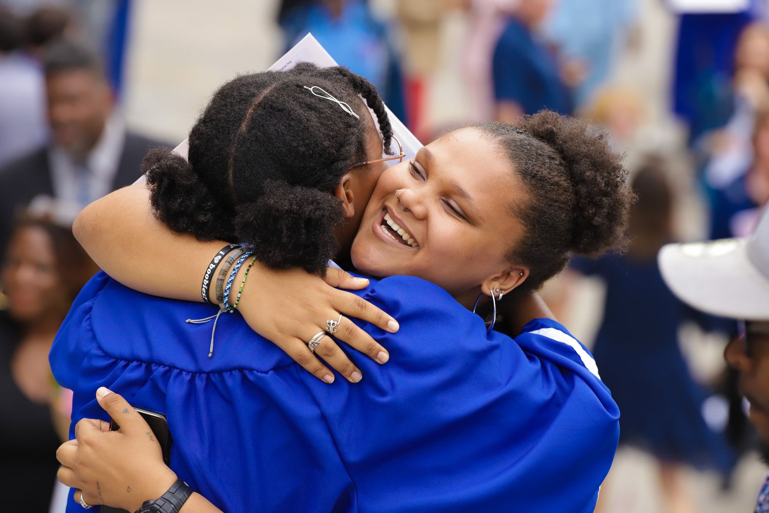 Graduate celebrating achievement with student after graduation ceremony Gwinnett county Georgia captured by Quinton Cole Media.