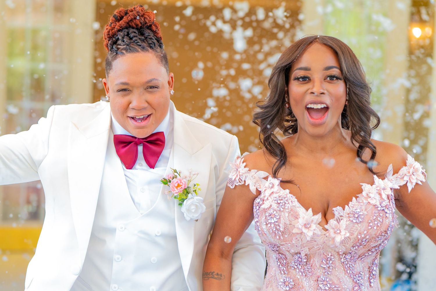 Romantic outdoor lesbian wedding ceremony captured by Quinton Cole Media, featuring a candid moment of newlyweds smiling during their exit.