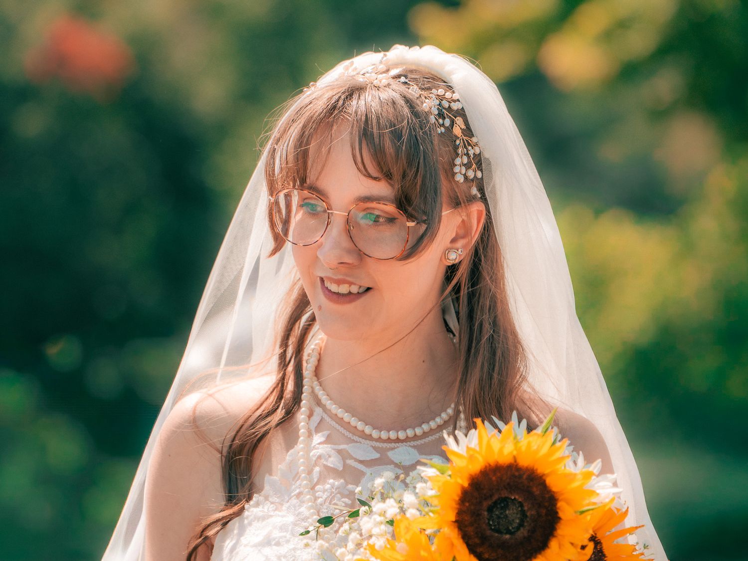 Bride with veil and sunflowers during outdoor North Georgia wedding, candid bridal portrait by Gwinnett County wedding photographer.
