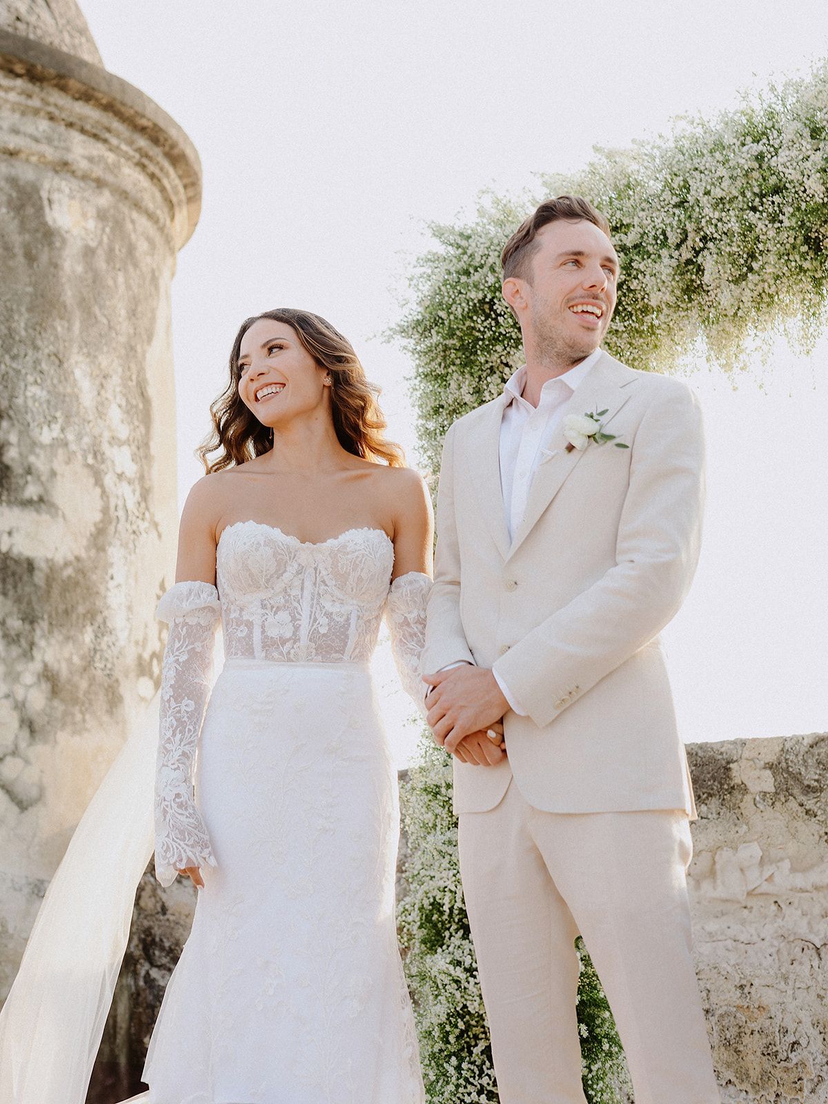 A romantic wedding portrait against historic stone architecture.