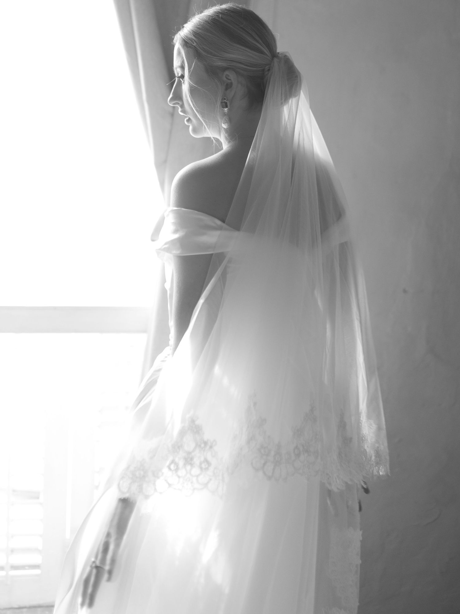 Classic black and white bridal portrait showing veil and off-shoulder dress details.
