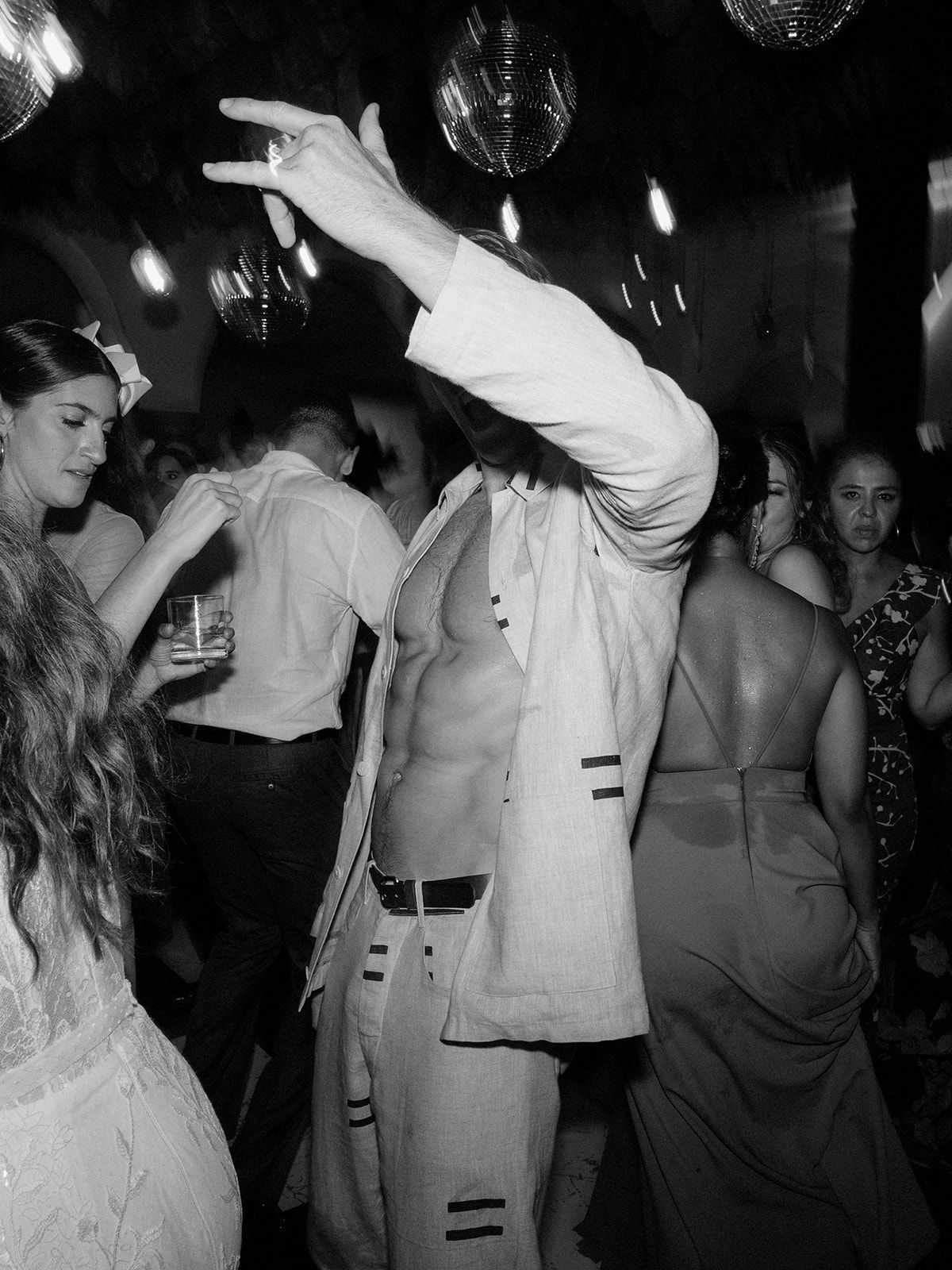 Black and white photo of wedding reception dance party with disco balls.