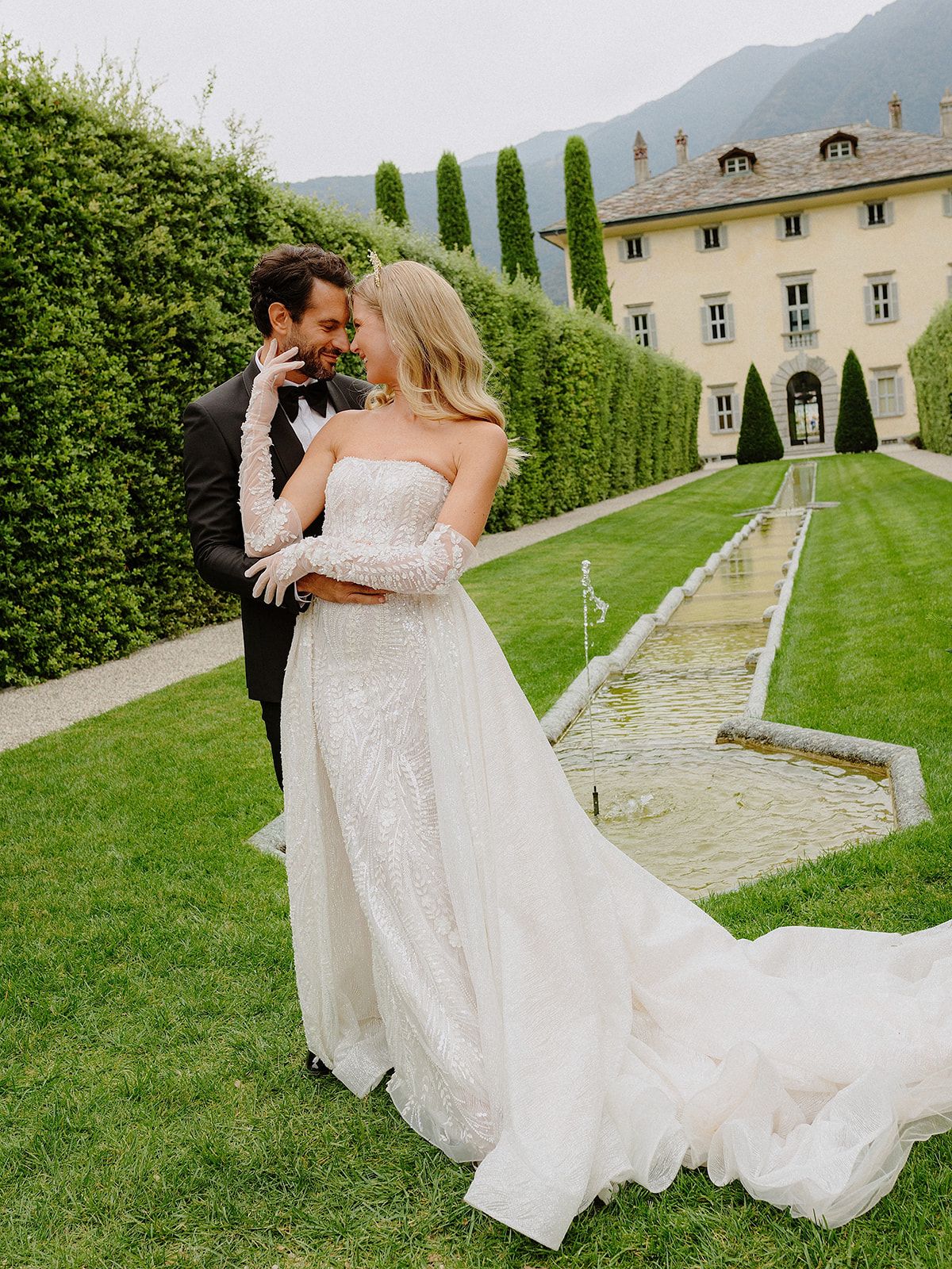 A romantic scene in an Italian garden with formal hedges and a grand villa in the background.