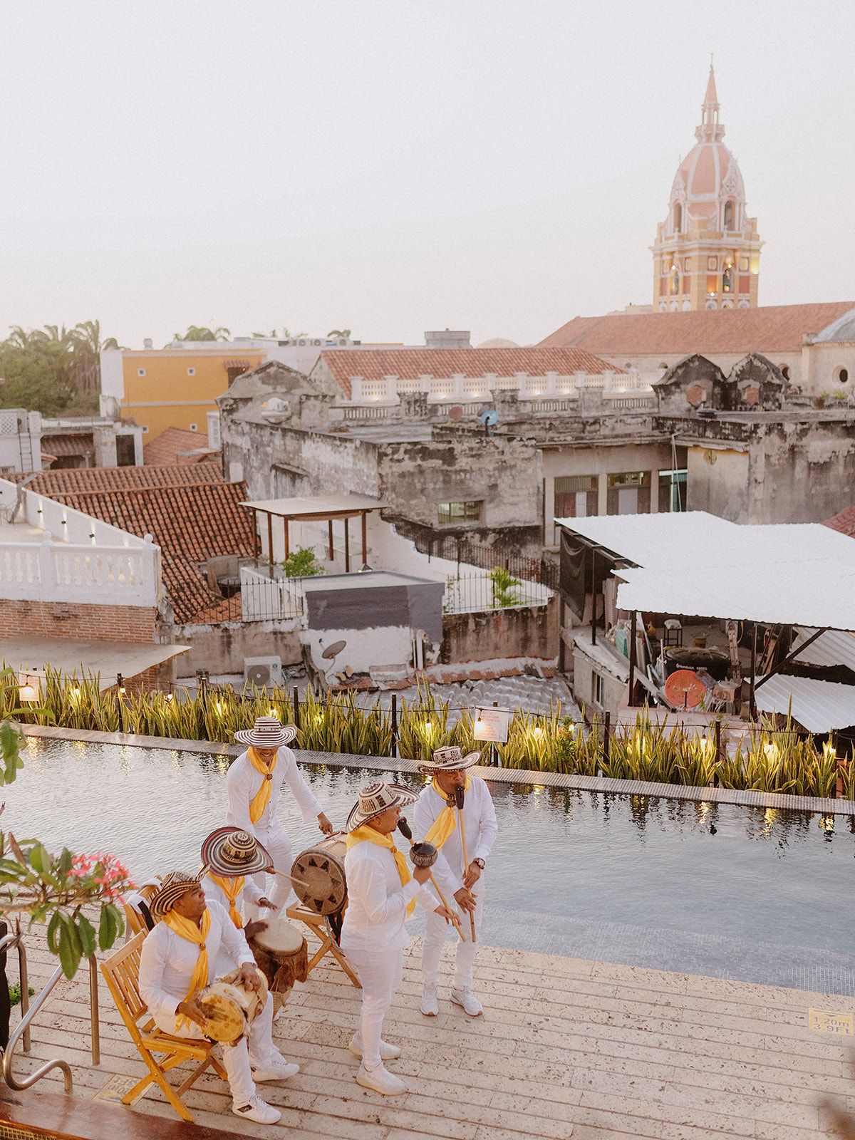 Rooftop gathering in Cartagena with colonial architecture and church dome in background.