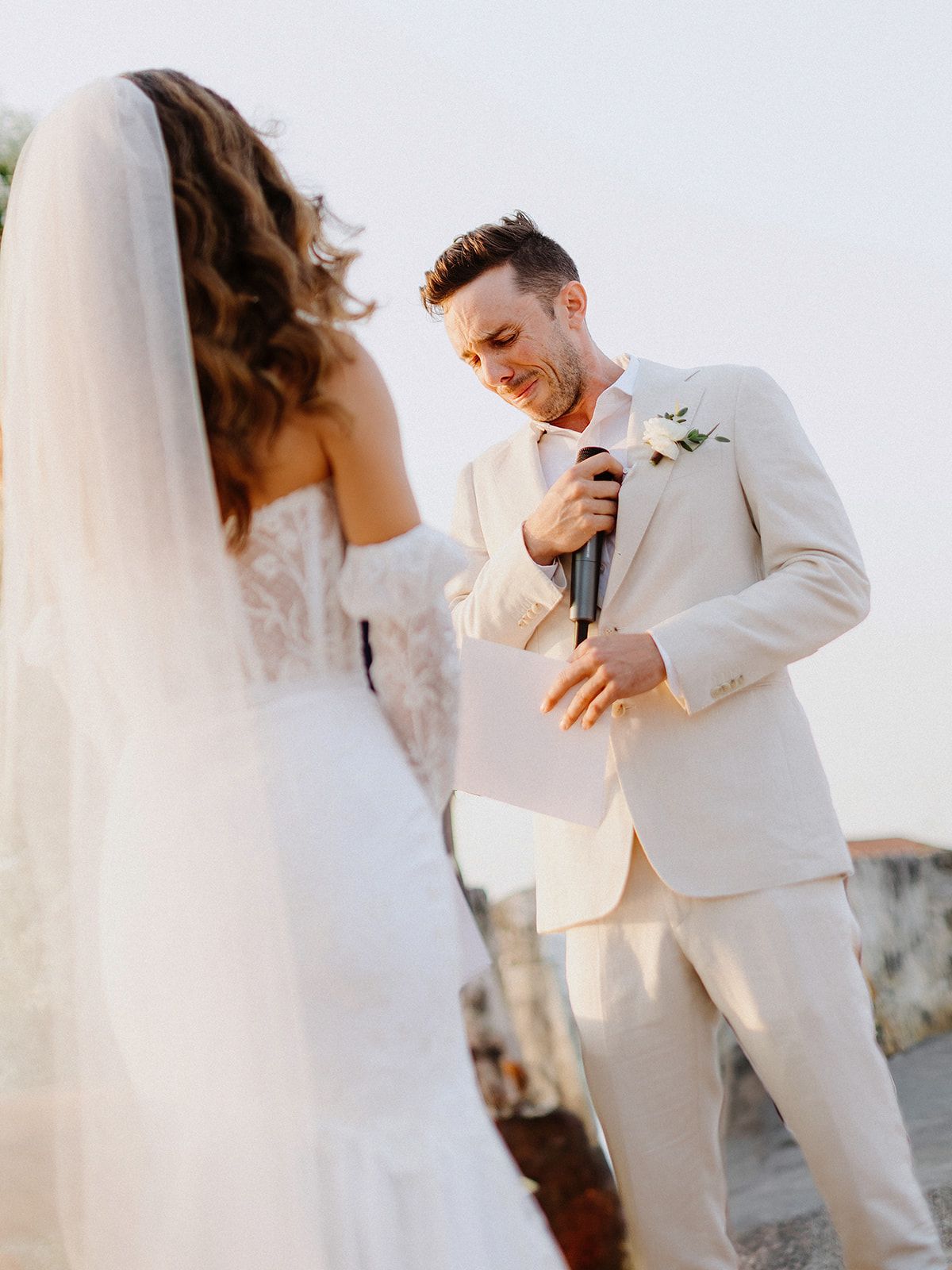 A tender moment between newlyweds during a sun-lit outdoor celebration.