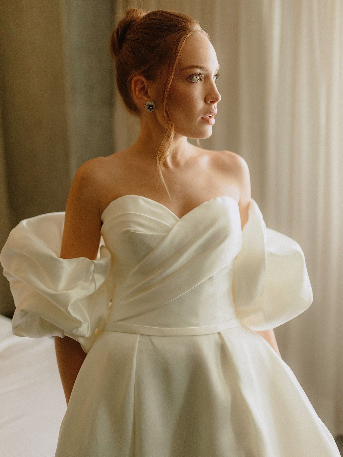 A stunning wedding gown with delicate off-shoulder puff sleeves and a sweetheart neckline in classic white.