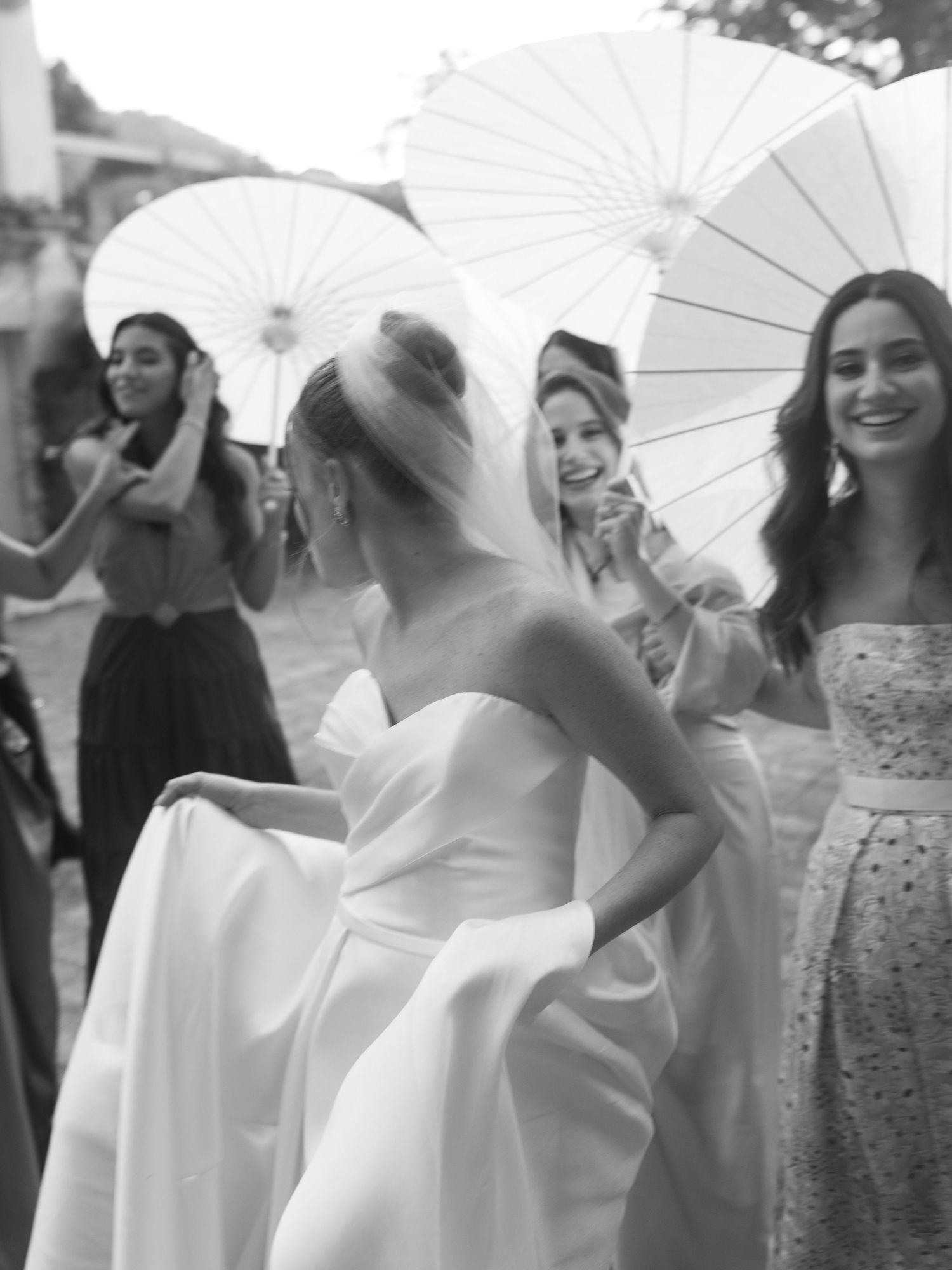 Wedding party with white parasols in black and white photography.