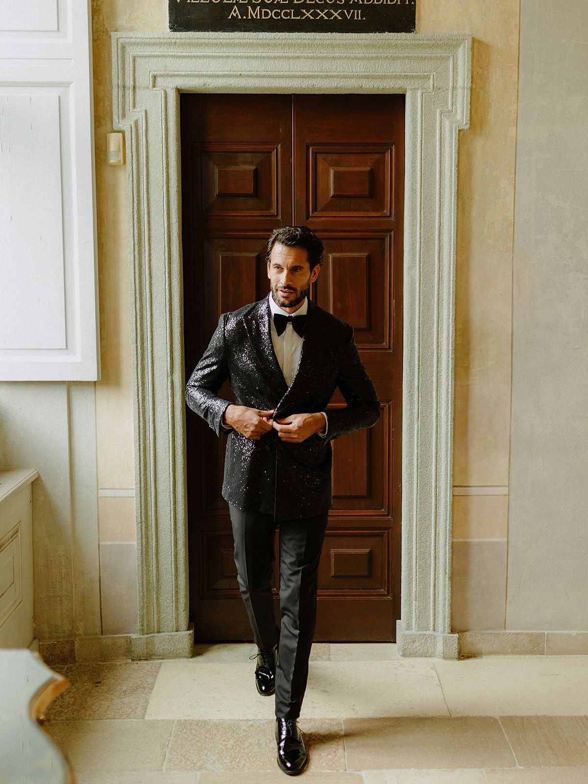 Elegant formal attire captured in a classic interior doorway setting.