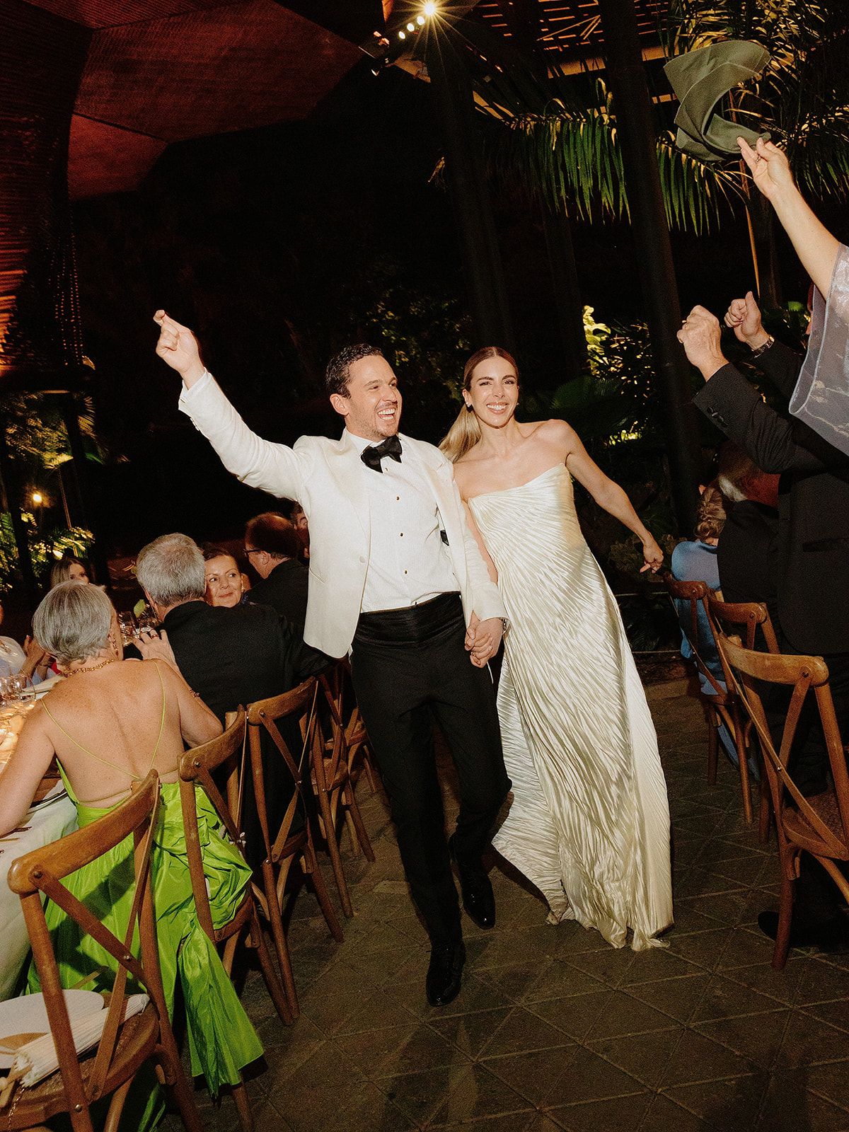 Wedding reception celebration with dancing guests in an elegantly lit venue.