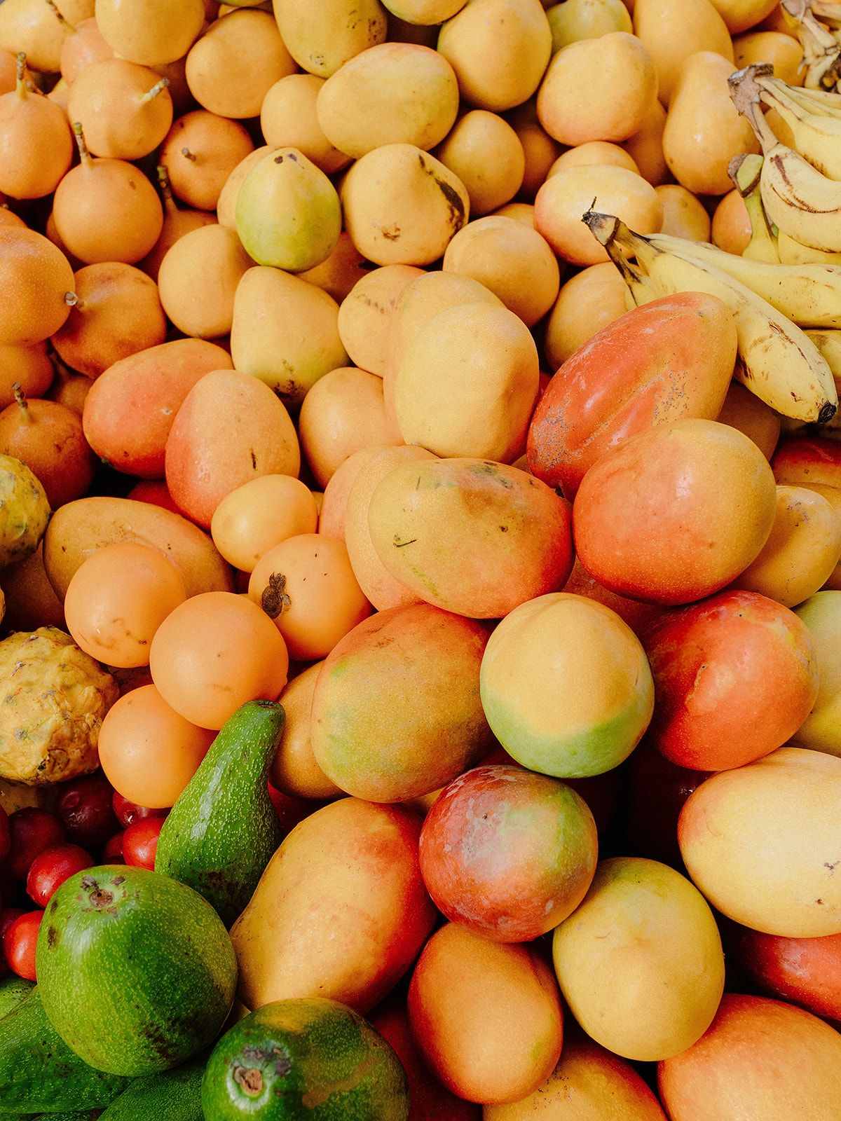 Fresh citrus fruits and limes in vibrant orange and green hues at market display.