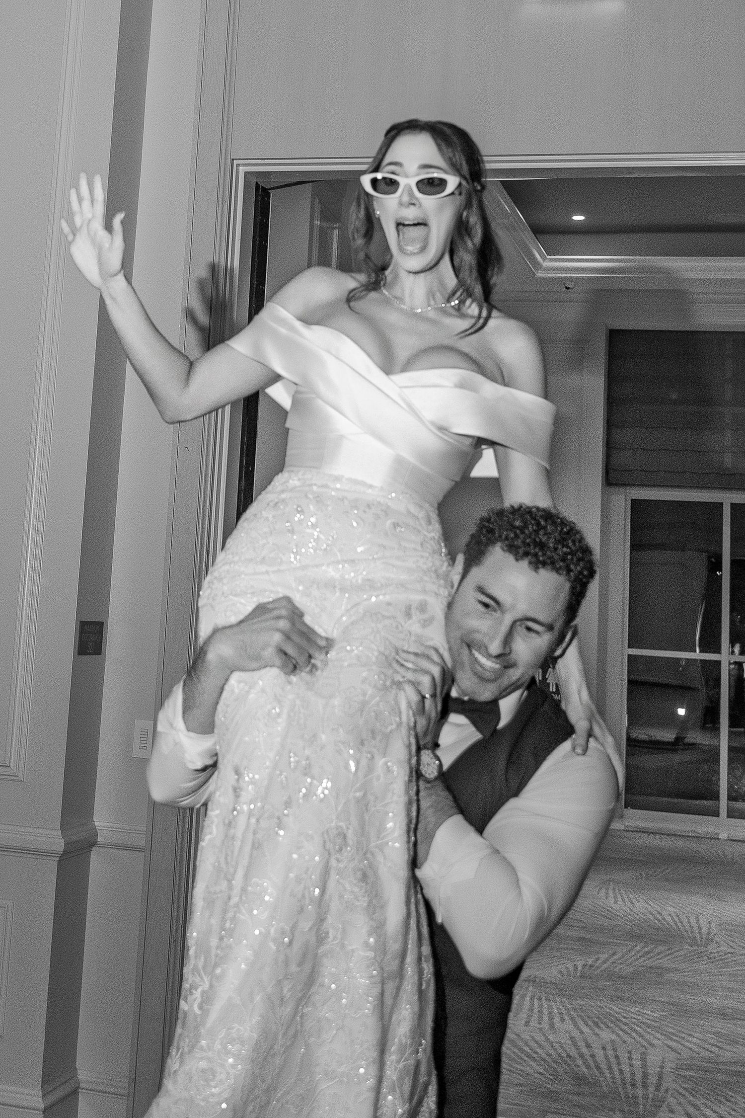 A series of four black and white photo booth style images showing a couple in wedding attire posing playfully together.