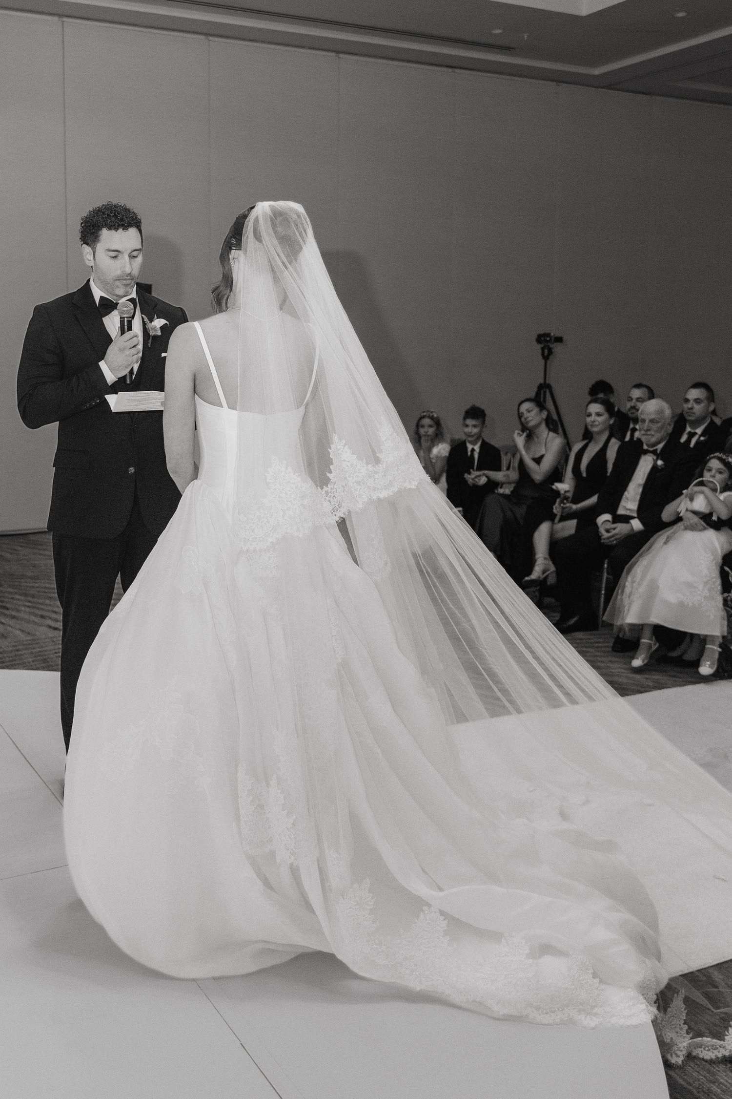 Black and white photo of bride and groom sharing first dance at elegant wedding reception.