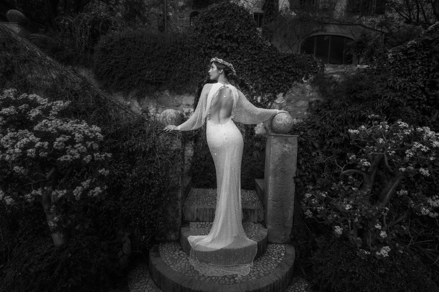 Black and white wedding photography in a romantic garden setting with blooming flowers.